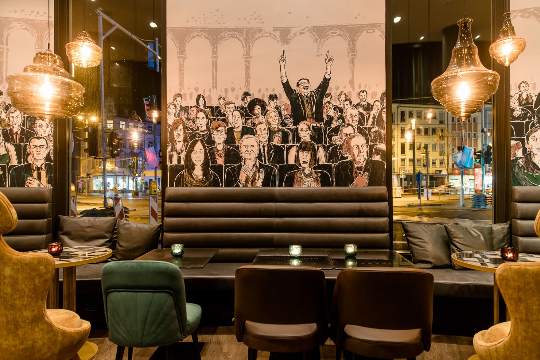 Hotel Bonn Beethoven Motel One große Lounge mit Blick auf mehrere Tische und Stühle und Blick nach draußen bei Abend