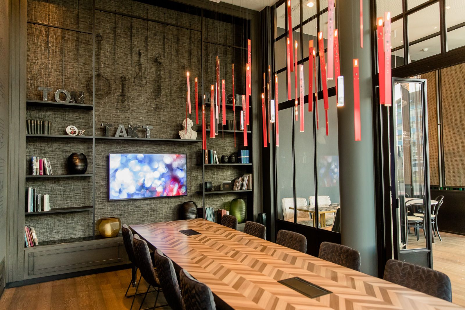 Hotel Bonn Beethoven Motel One heller Meetingraum mit langem Tisch und mehreren Stühlen sowie ein Fernseher an der Wand