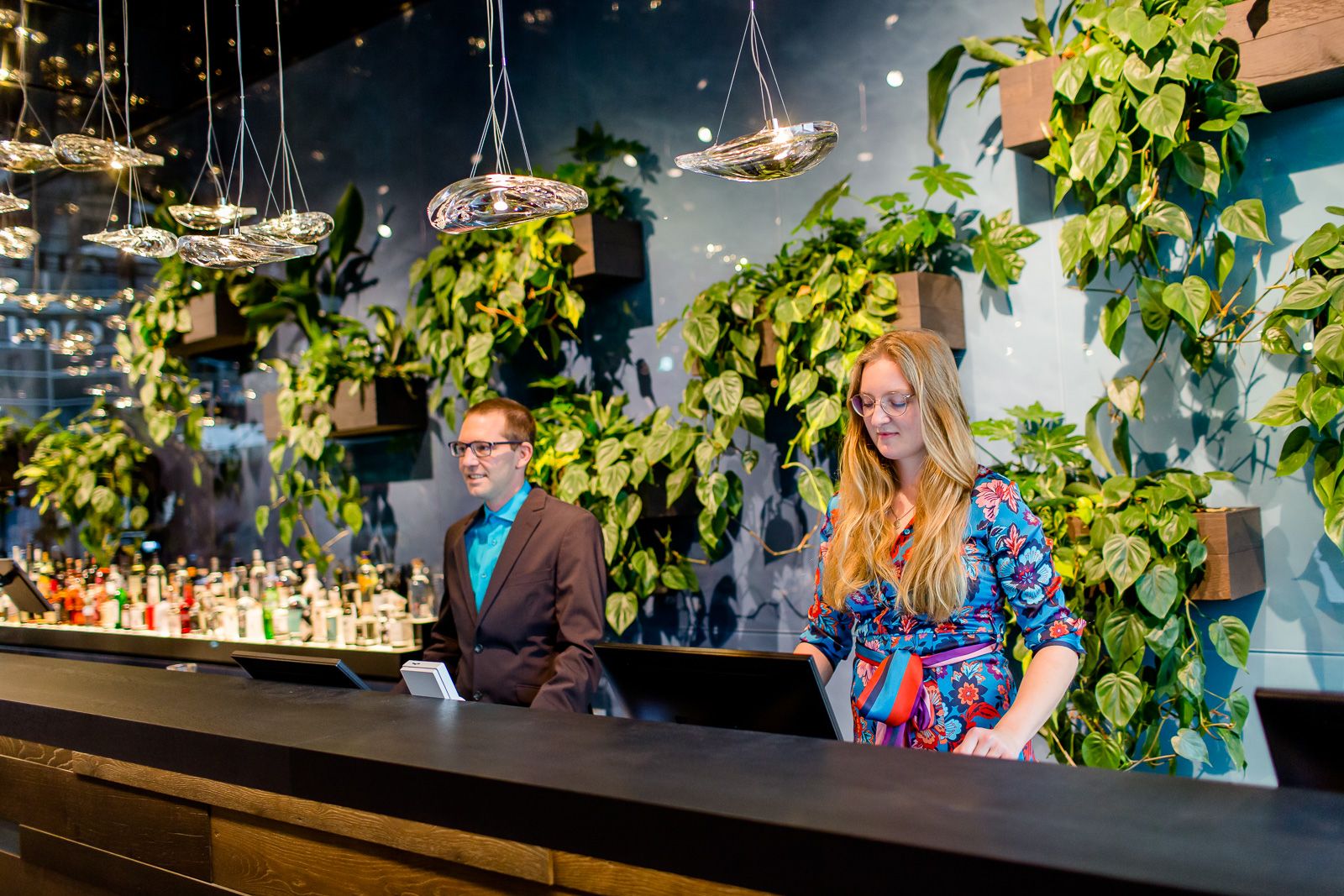 Hotel Bonn Hauptbahnhof Motel One Rezeption mit zwei Mitarbeitenden bei der Arbeit sowie die Bar im Hintergrund