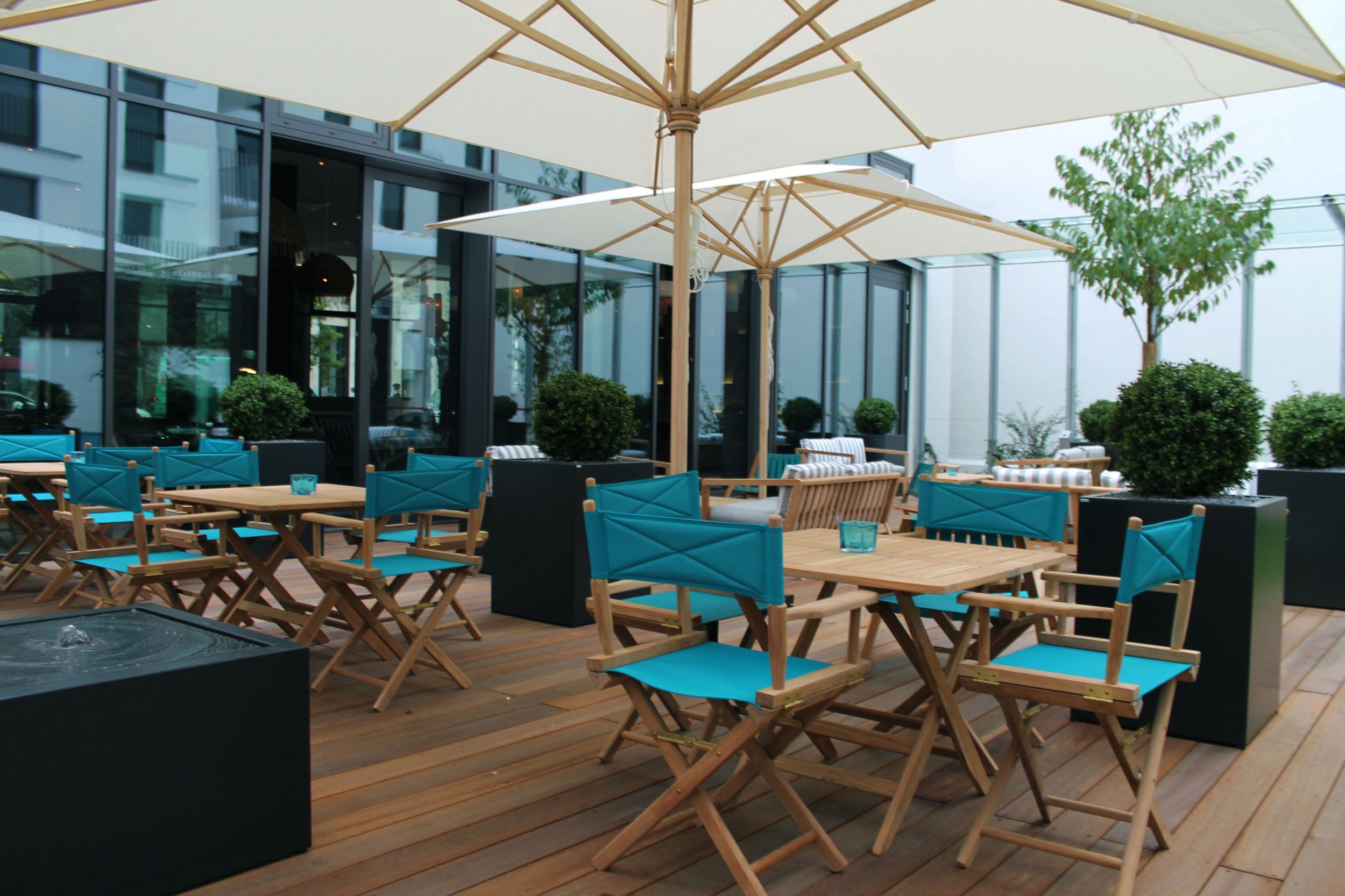Hotel Bremen Motel One Terrasse mit mehreren Sitzgelegenheiten sowie zwei Sonnenschirmen