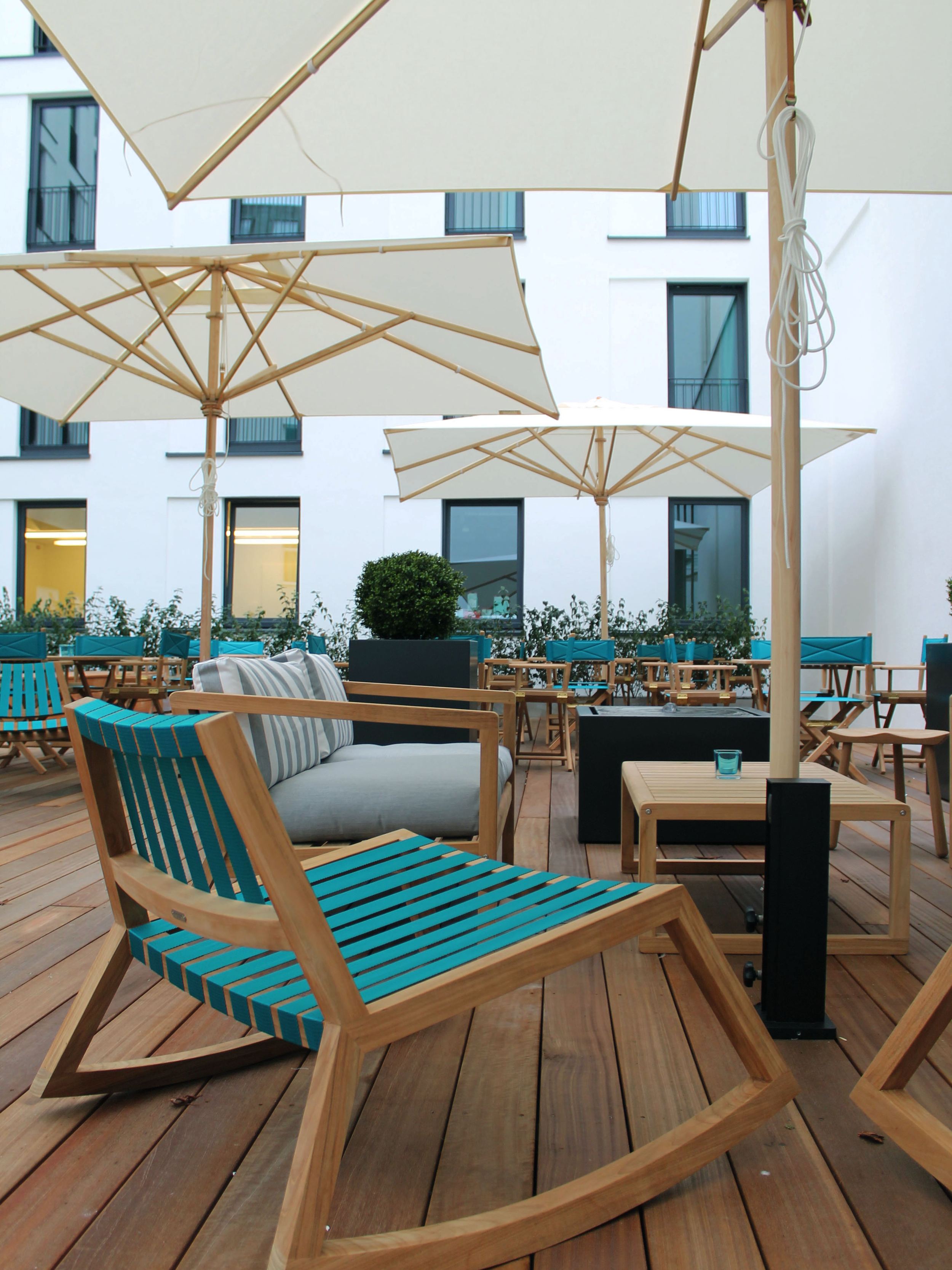 designhotel Bremen Motel One large terrace with several tables and chairs and three large parasols