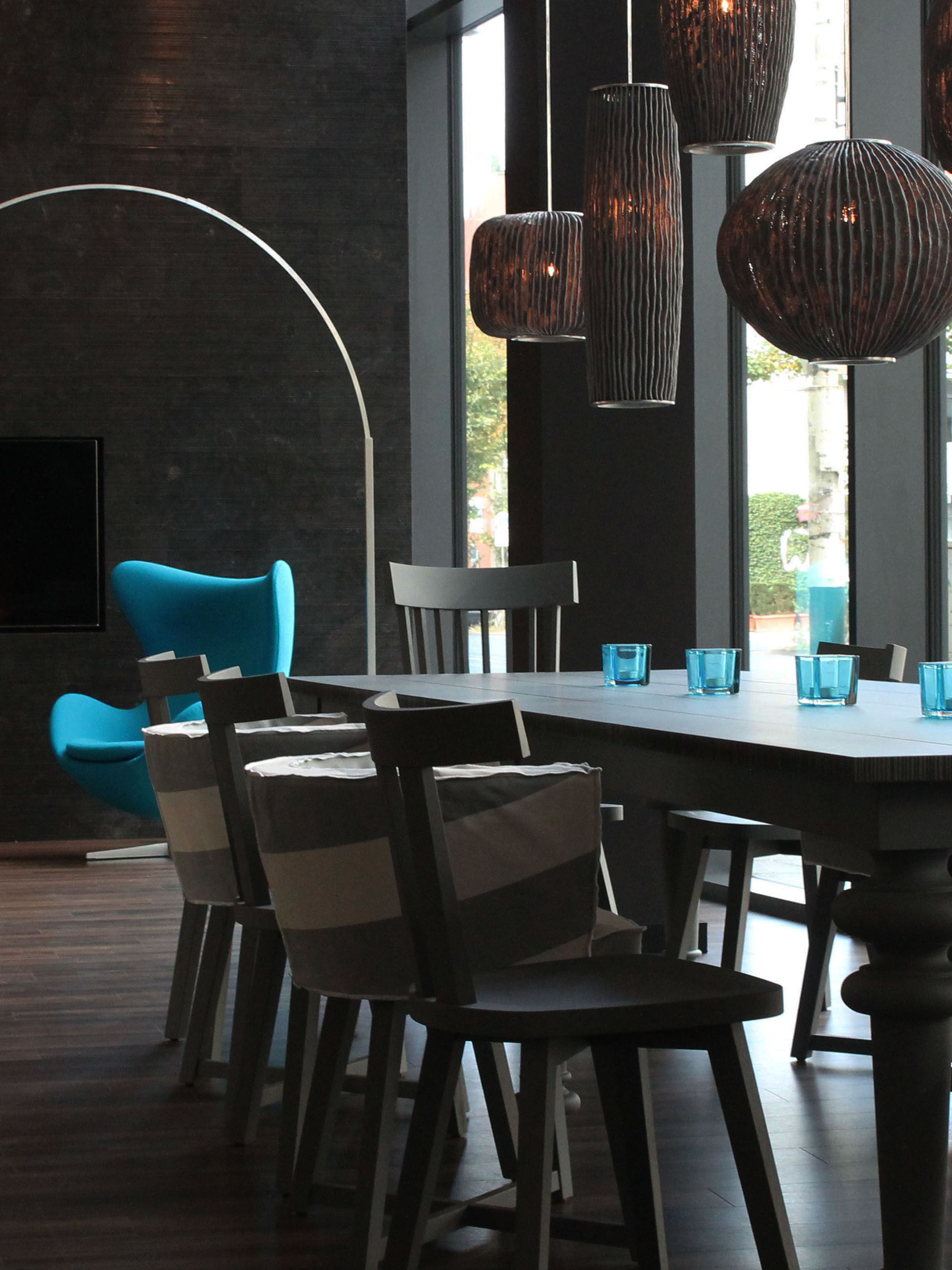 designhotel Bremen Motel One lounge with large window front, long table, and two Egg Chairs in the background