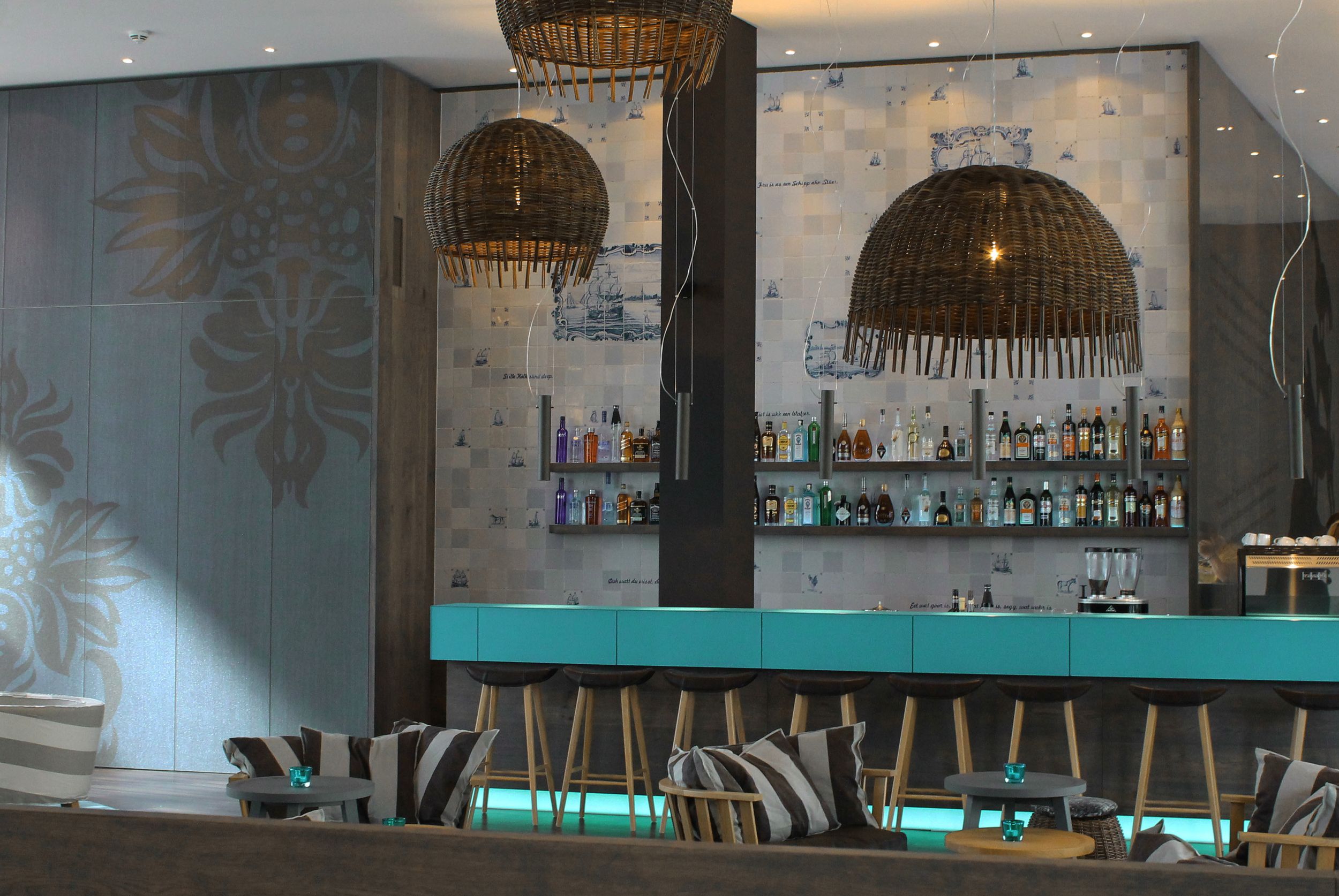 Hotel Bremen Motel One Lounge mit Blick auf eine große Bar mit Barhockern und Spirituosen an der Wand