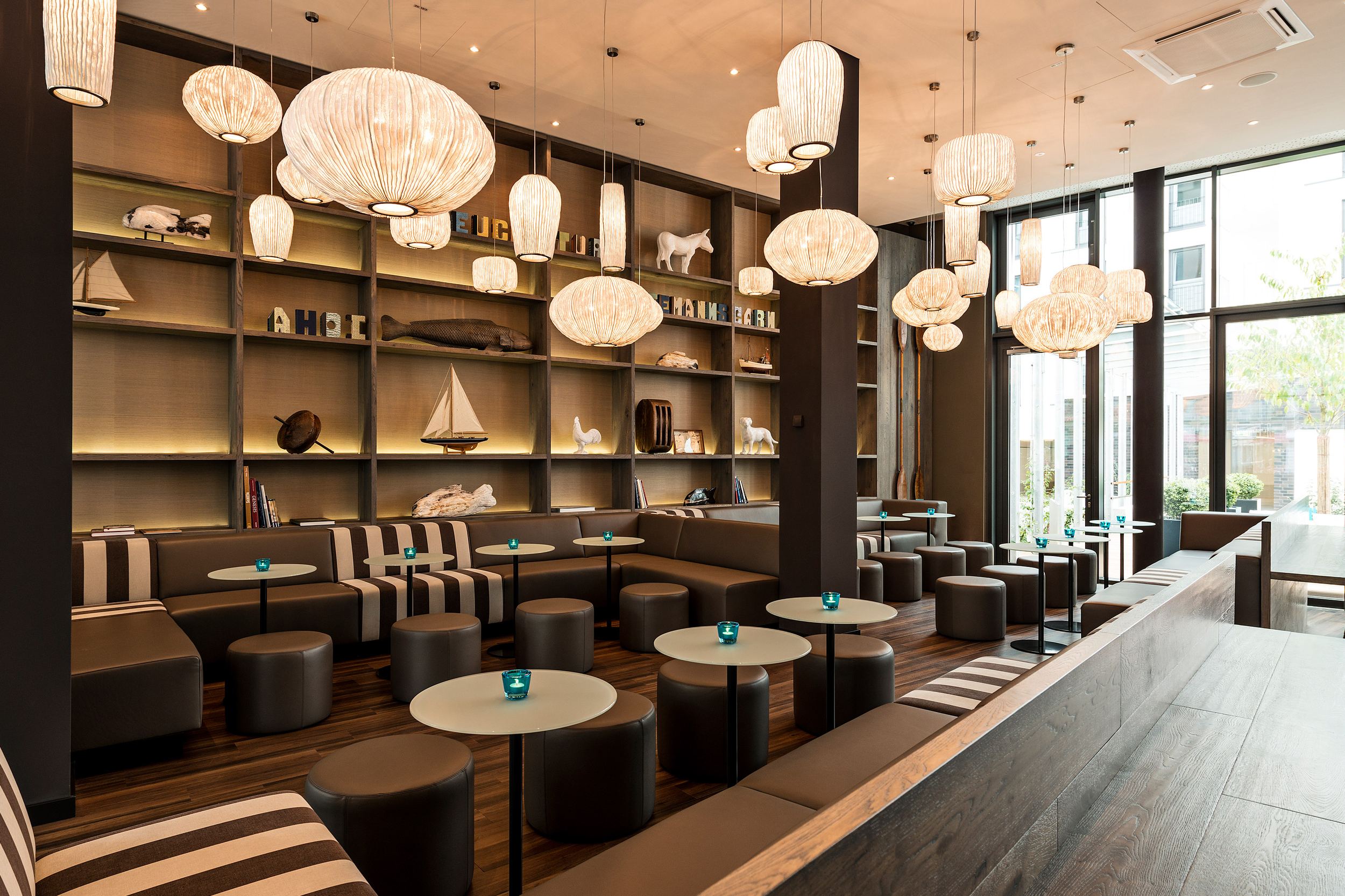 hotel Bremen Motel One large, bright lounge with plenty of seating, floor-to-ceiling windows, and a view of the terrace