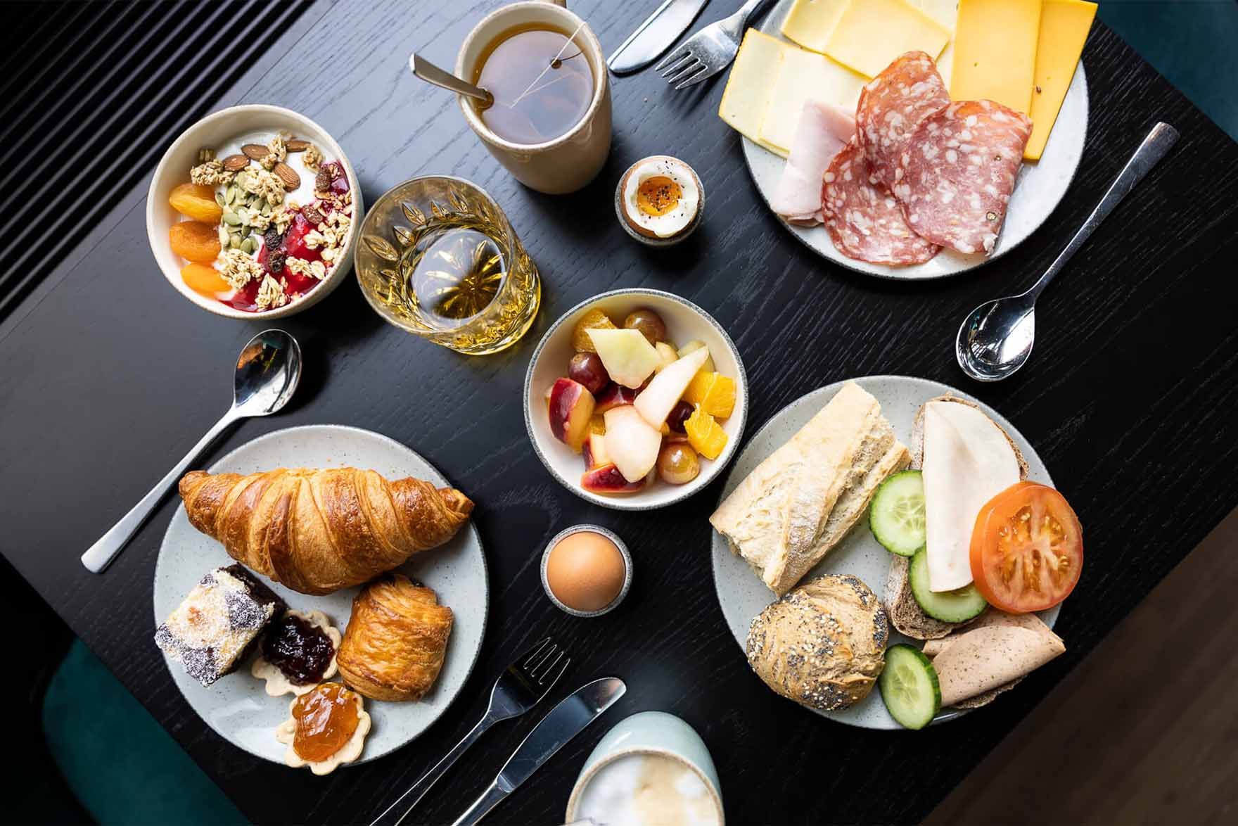 Designhotel Brüssel Motel One Blick von oben auf einen gedeckten Frühstückstisch mit mehreren Speisen und Getränken
