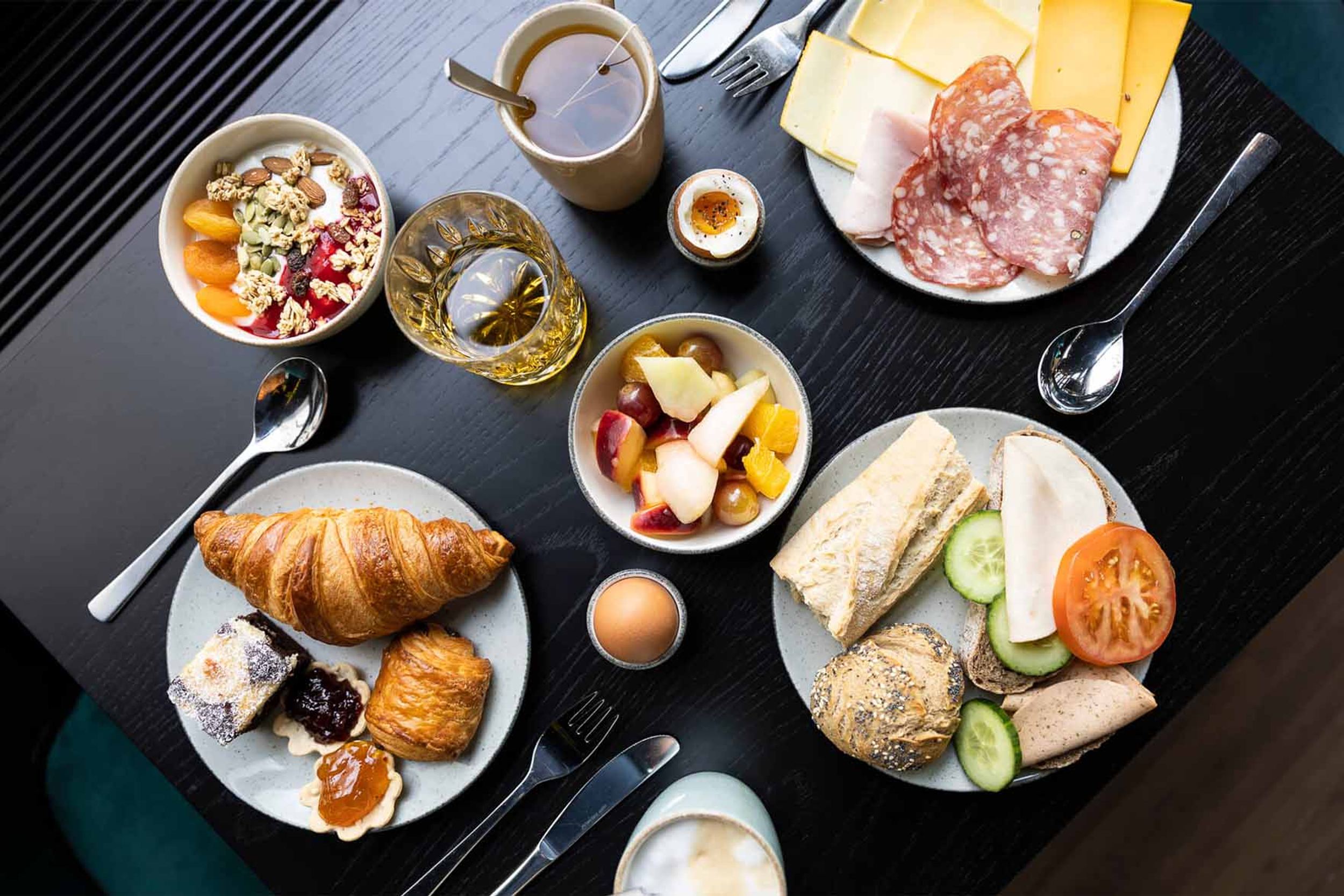 Designhotel Brüssel Motel One Blick von oben auf einen gedeckten Frühstückstisch mit mehreren Speisen und Getränken
