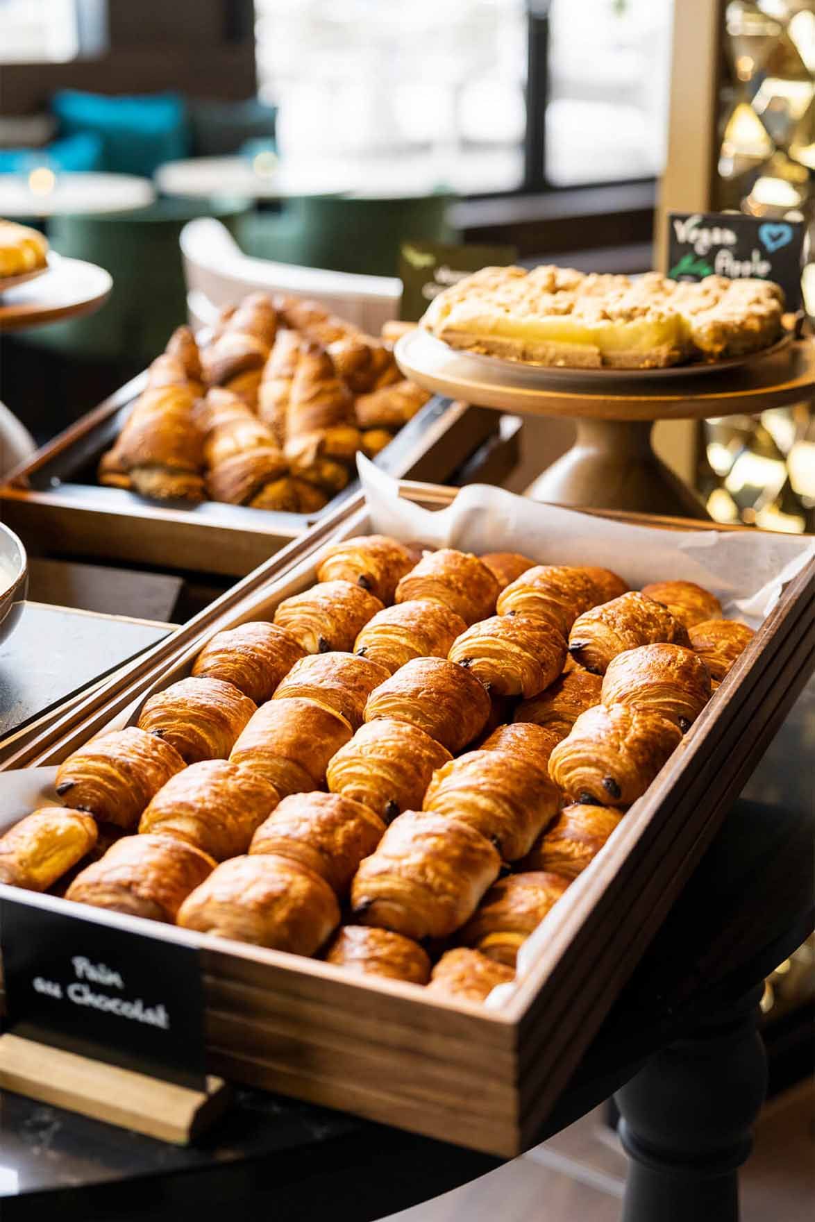 Designhotel Brüssel Motel One Frühstücksbuffet mit Nahaufnahme auf einen Korb mit Pain au Chocolat