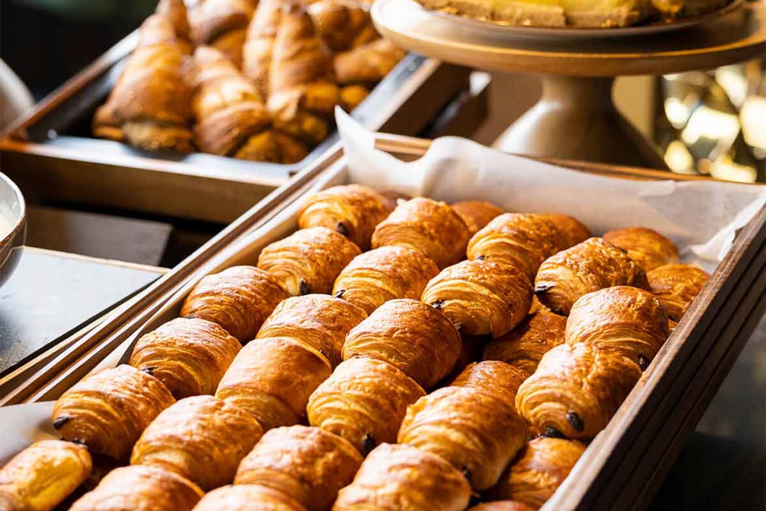 Designhotel Brüssel Motel One Frühstücksbuffet mit Nahaufnahme auf einen Korb mit Pain au Chocolat