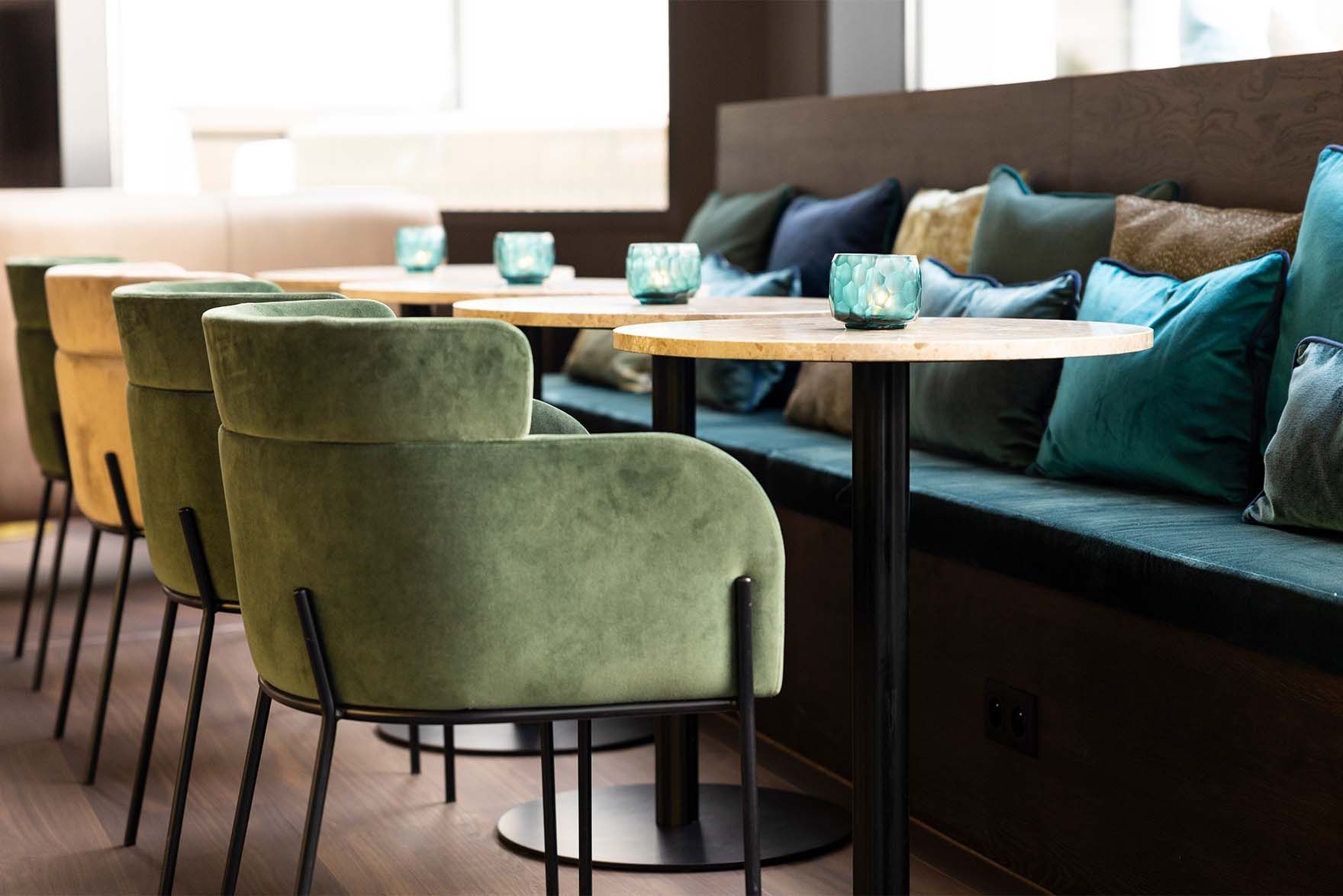 Designhotel Brüssel Motel One Lounge mit Blick auf mehrere Sessel, Tische und eine lange Sitzbank