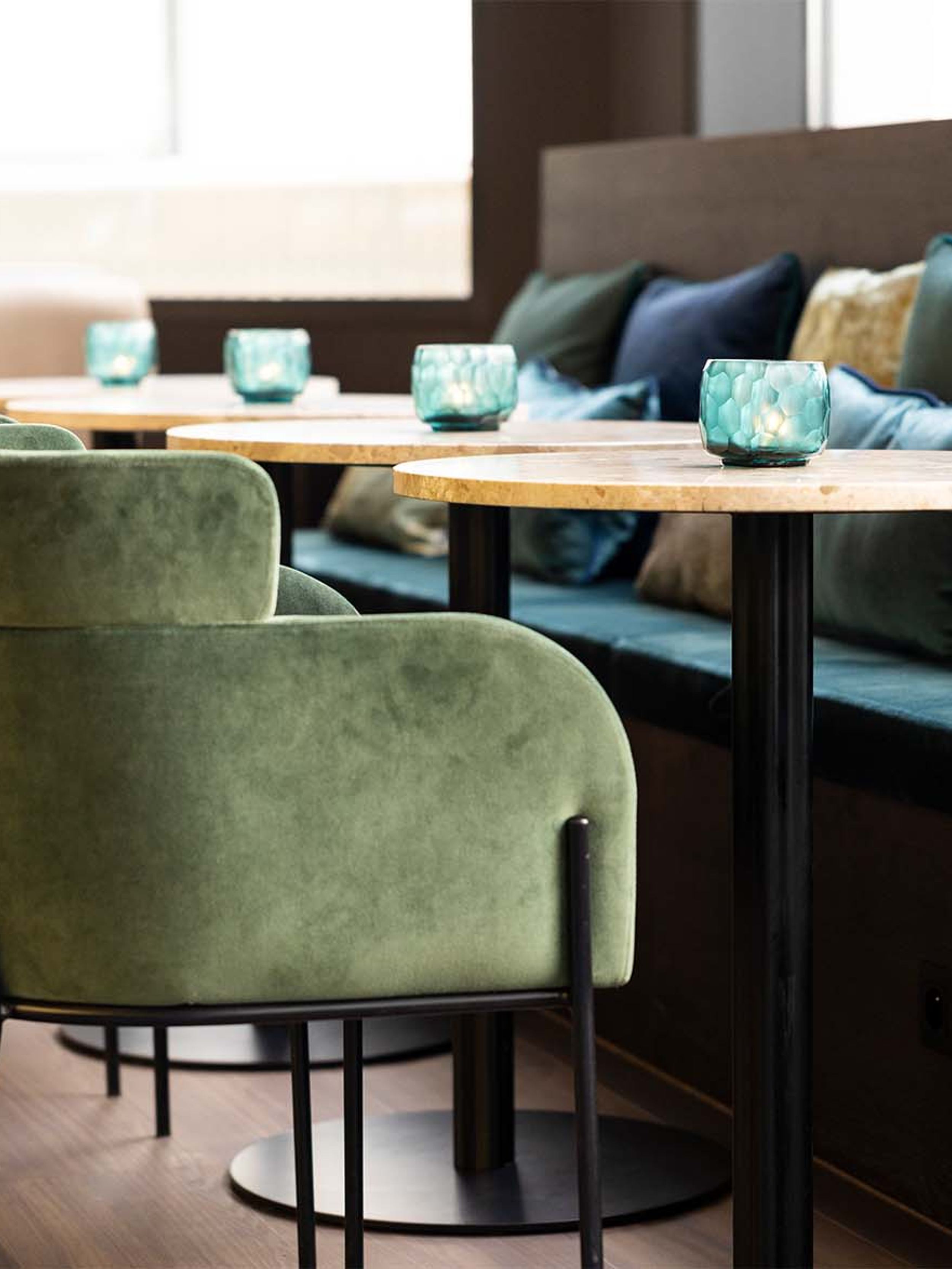 Designhotel Brüssel Motel One Lounge mit Blick auf mehrere Sessel, Tische und eine lange Sitzbank