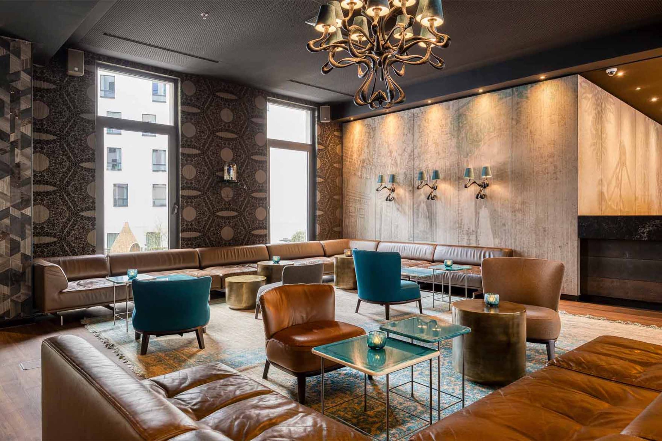 Designhotel Brüssel Motel One helle Lounge mit bodentiefen Fenstern und mehreren Sitzgelegenheiten