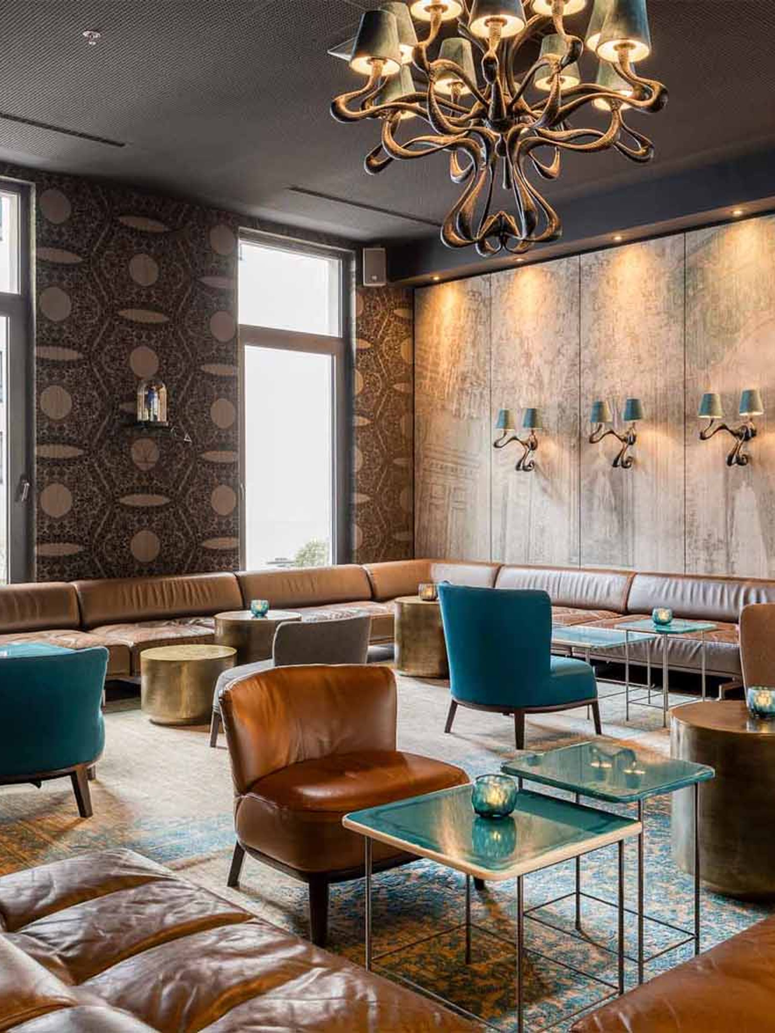 Designhotel Brüssel Motel One helle Lounge mit bodentiefen Fenstern und mehreren Sitzgelegenheiten