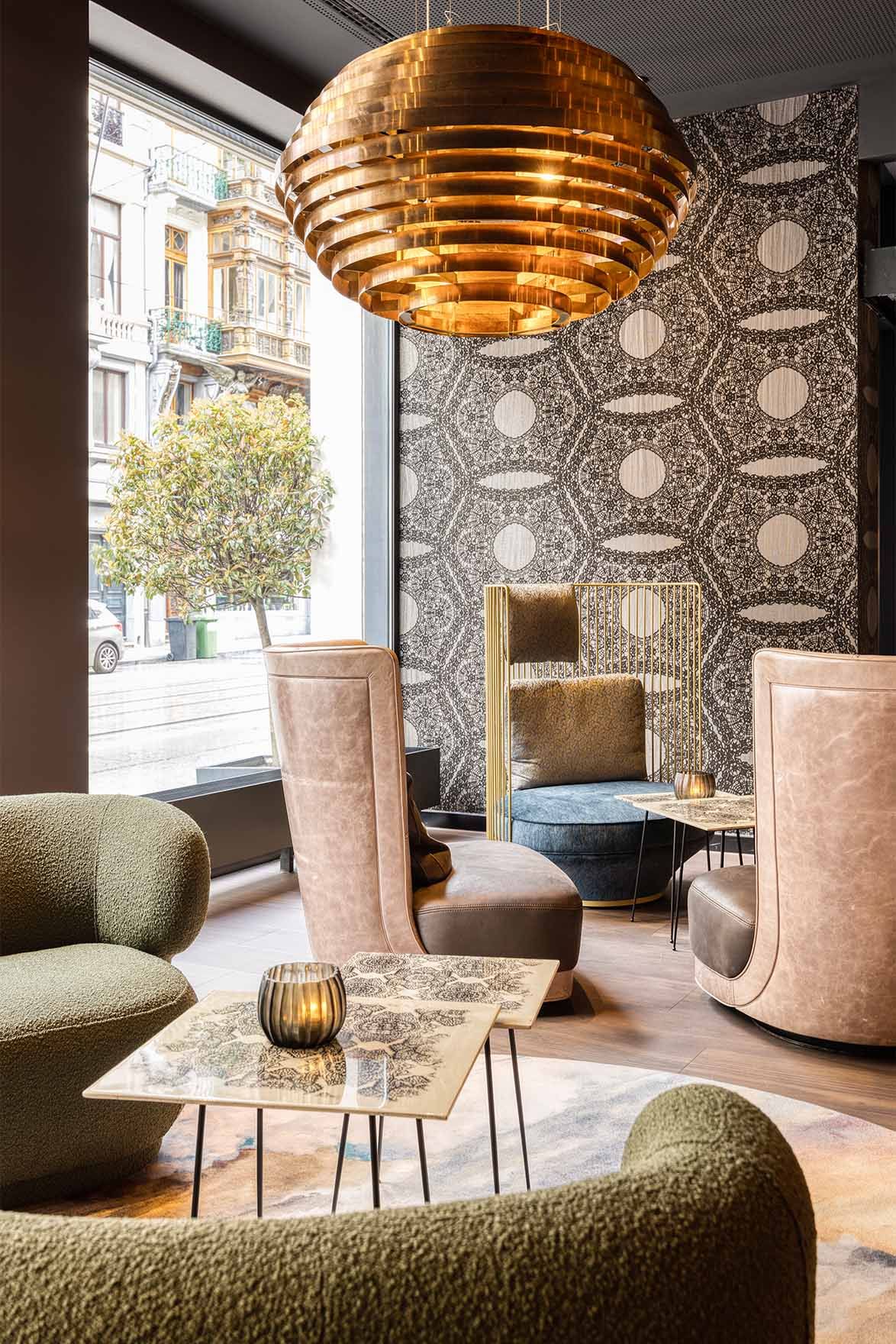 Designhotel Brüssel Motel One lichtdurchflutete Lounge mit Sesseln vor bodentiefem Fenster