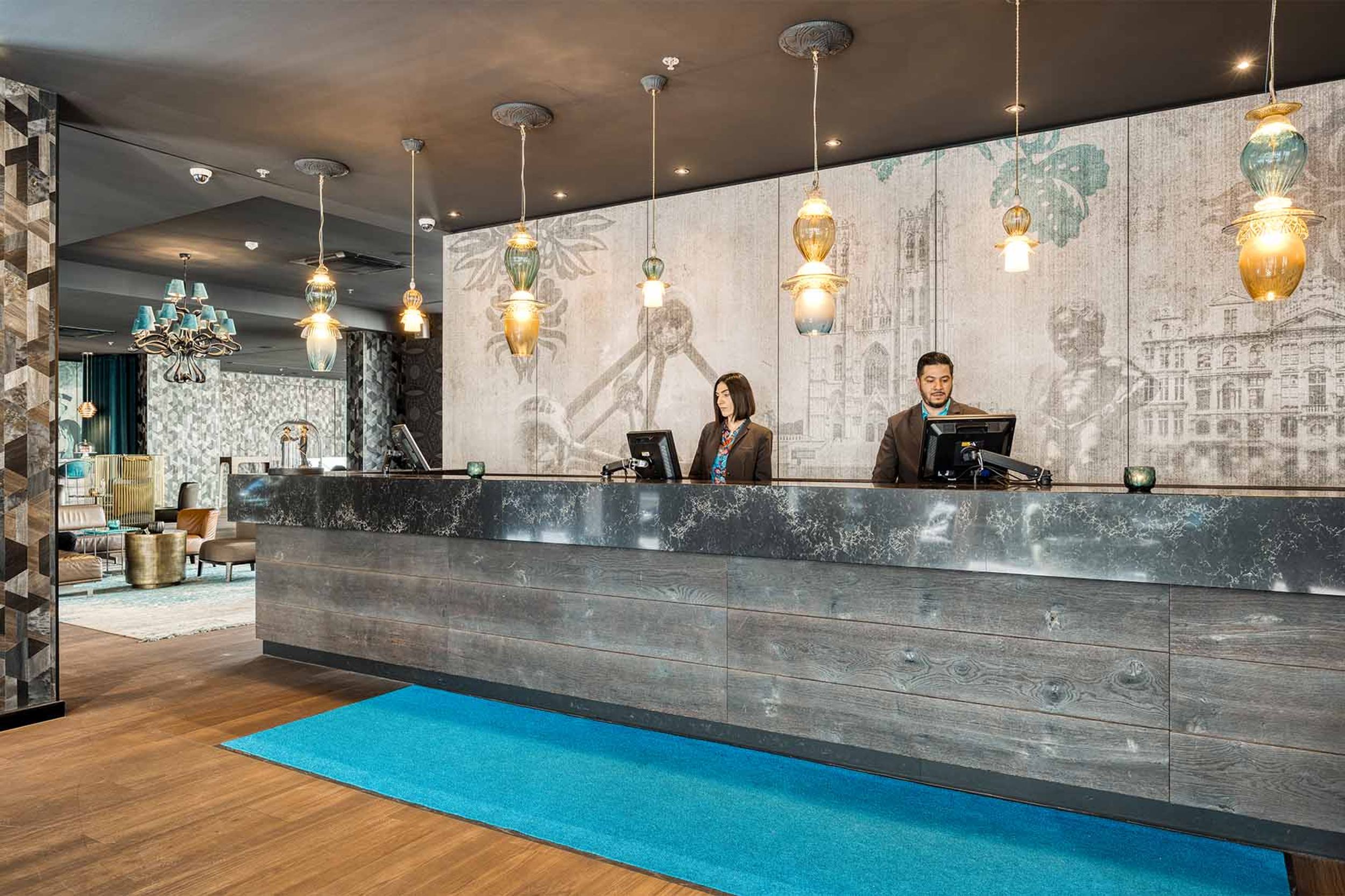 Designhotel Brüssel Motel One Rezeption mit zwei Mitarbeitenden