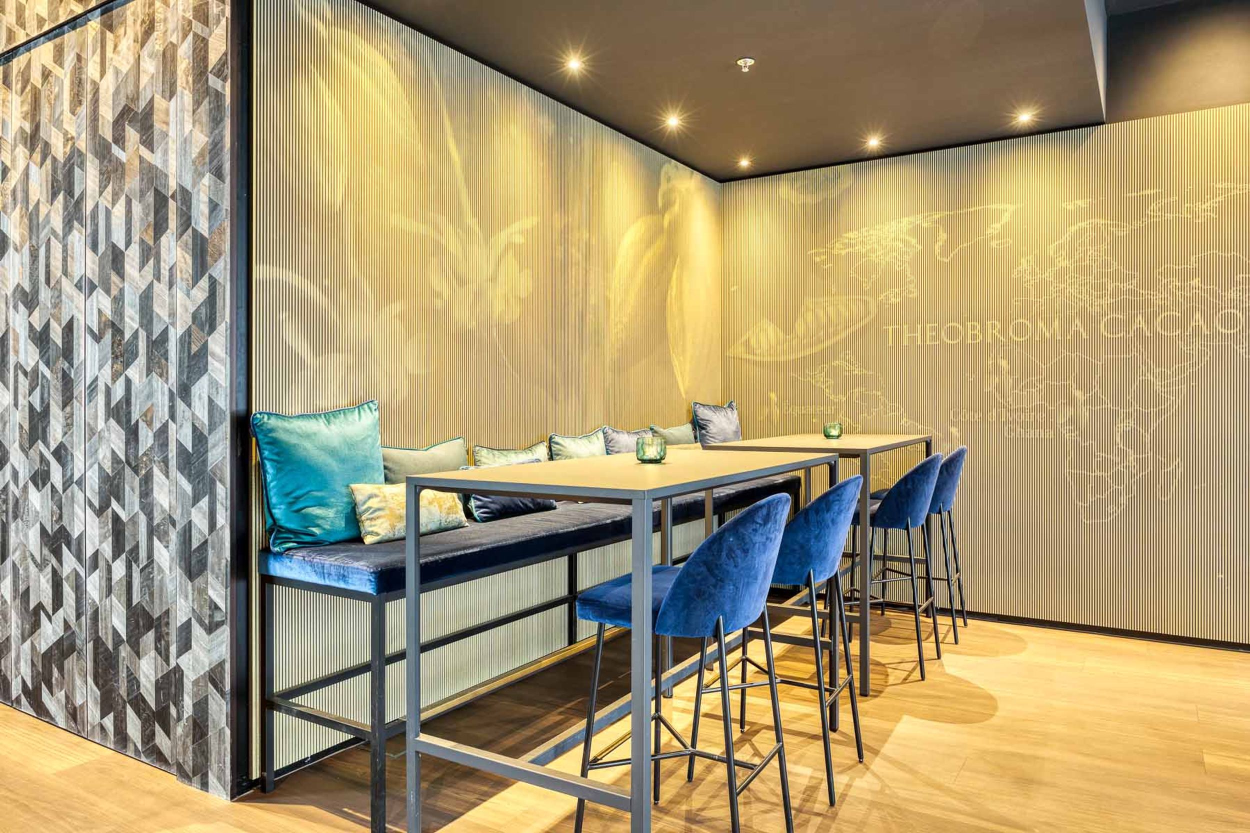 Designhotel Brüssel Motel One Lounge mit Blick auf einen Hochtisch und mehrere Stühle