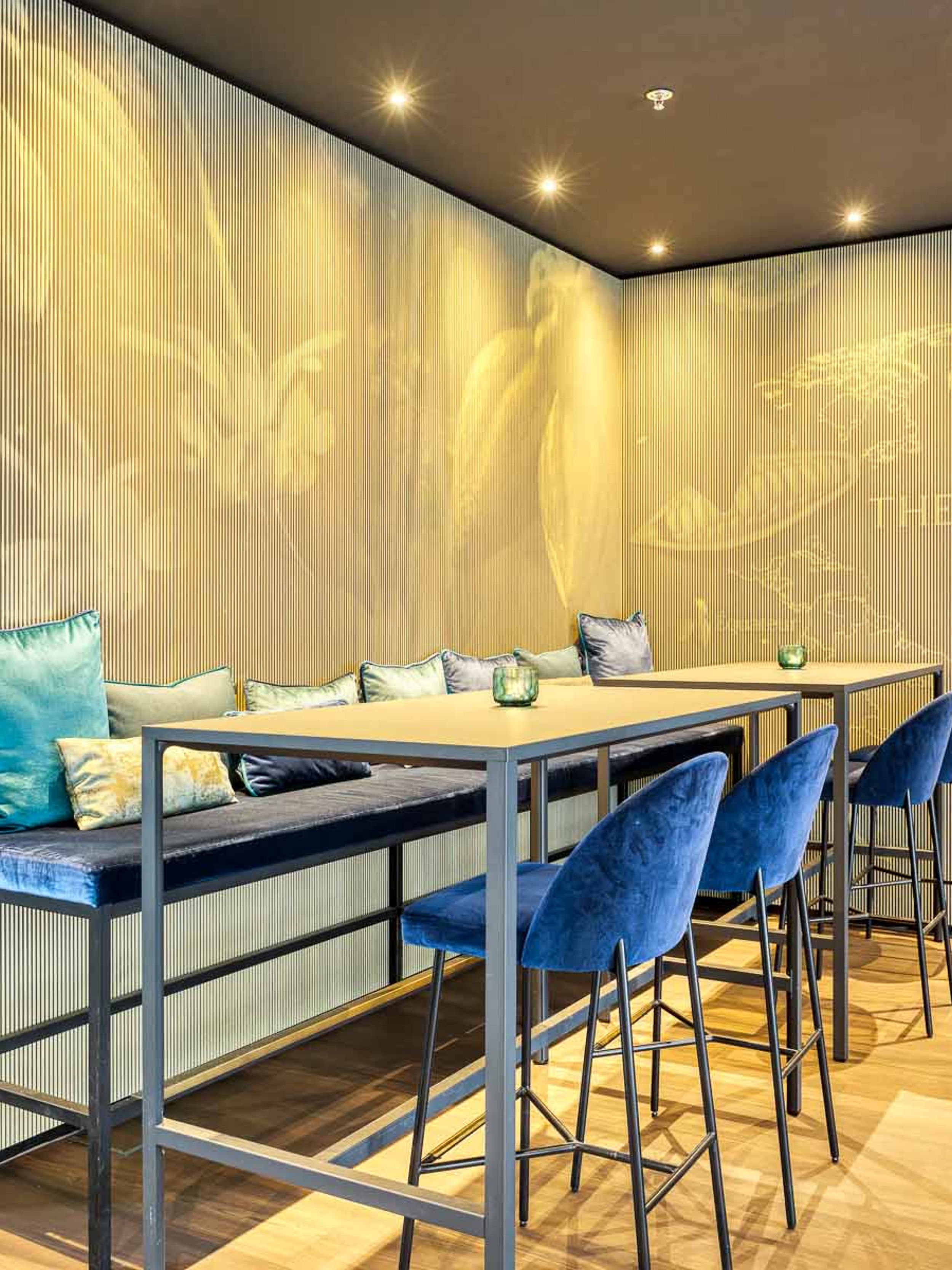 Designhotel Brüssel Motel One Lounge mit Blick auf einen Hochtisch und mehrere Stühle