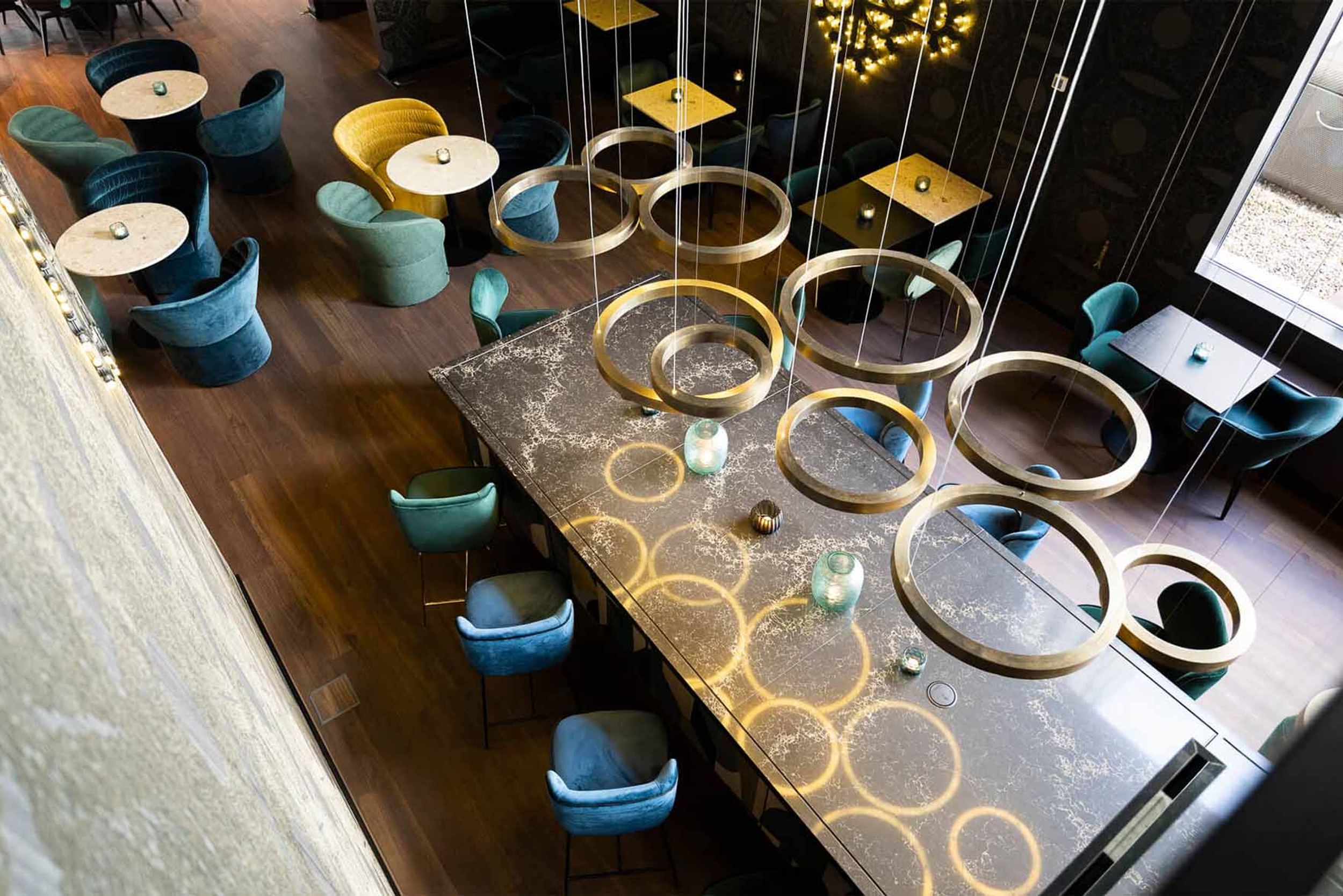 Designhotel Brüssel Motel One Blick von oben auf auf die Lounge mit mehreren Tischen und Stühlen