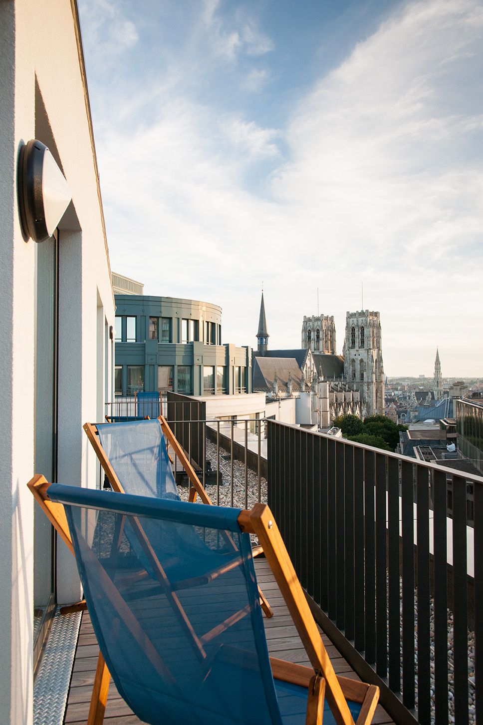Designhotel Brüssel Motel One Balkon mit Liegestühlen und Aussicht über die Dächer der Stadt