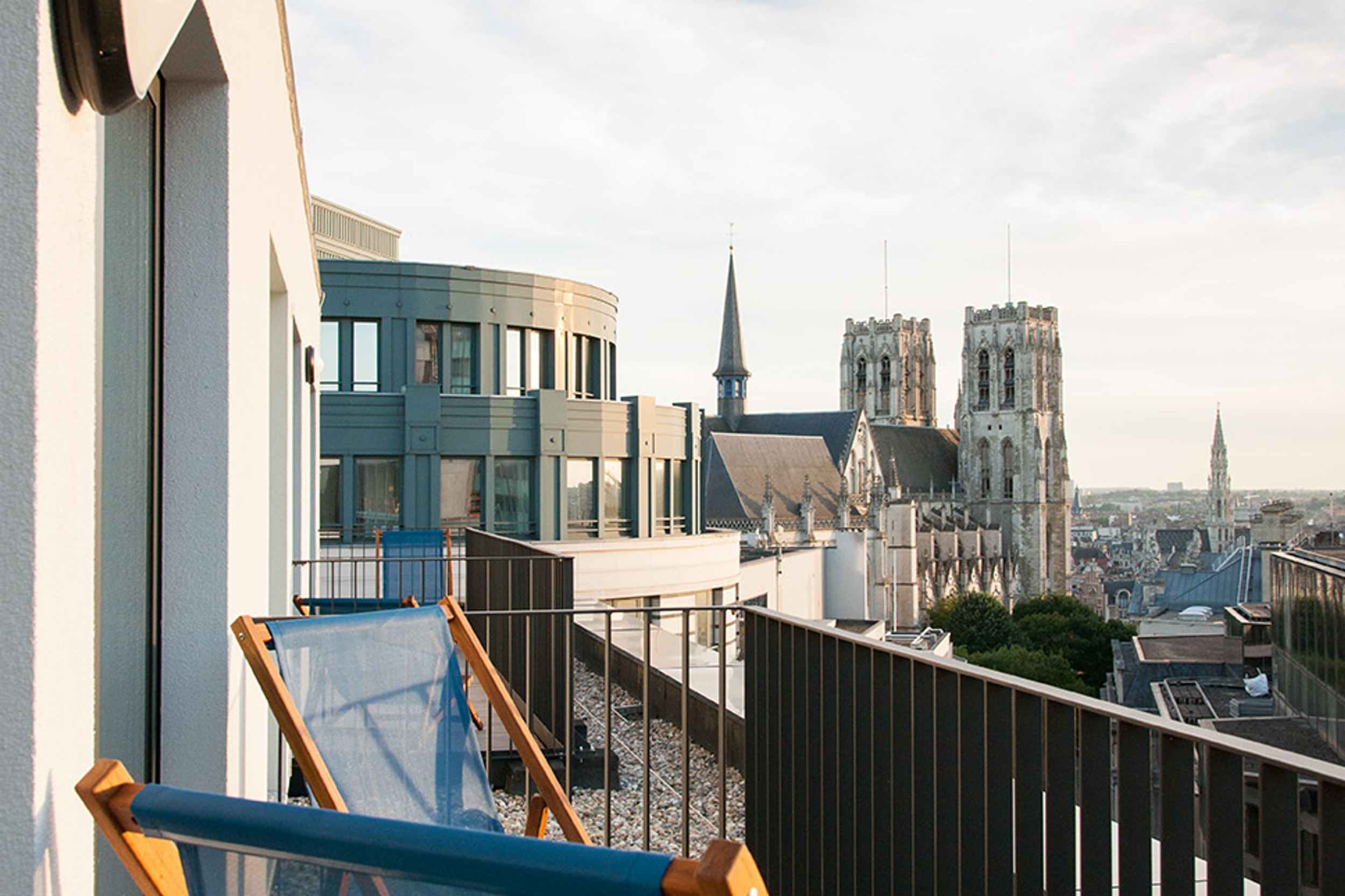 Designhotel Brüssel Motel One Balkon mit Liegestühlen und Aussicht über die Dächer der Stadt