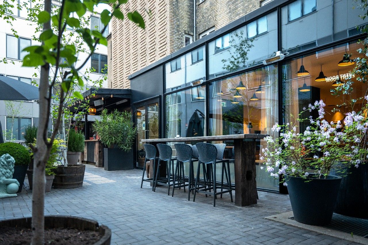 Hotel Kopenhagen Motel One Innenhof mit Sitzgelegenheiten und vielen Pflanzen