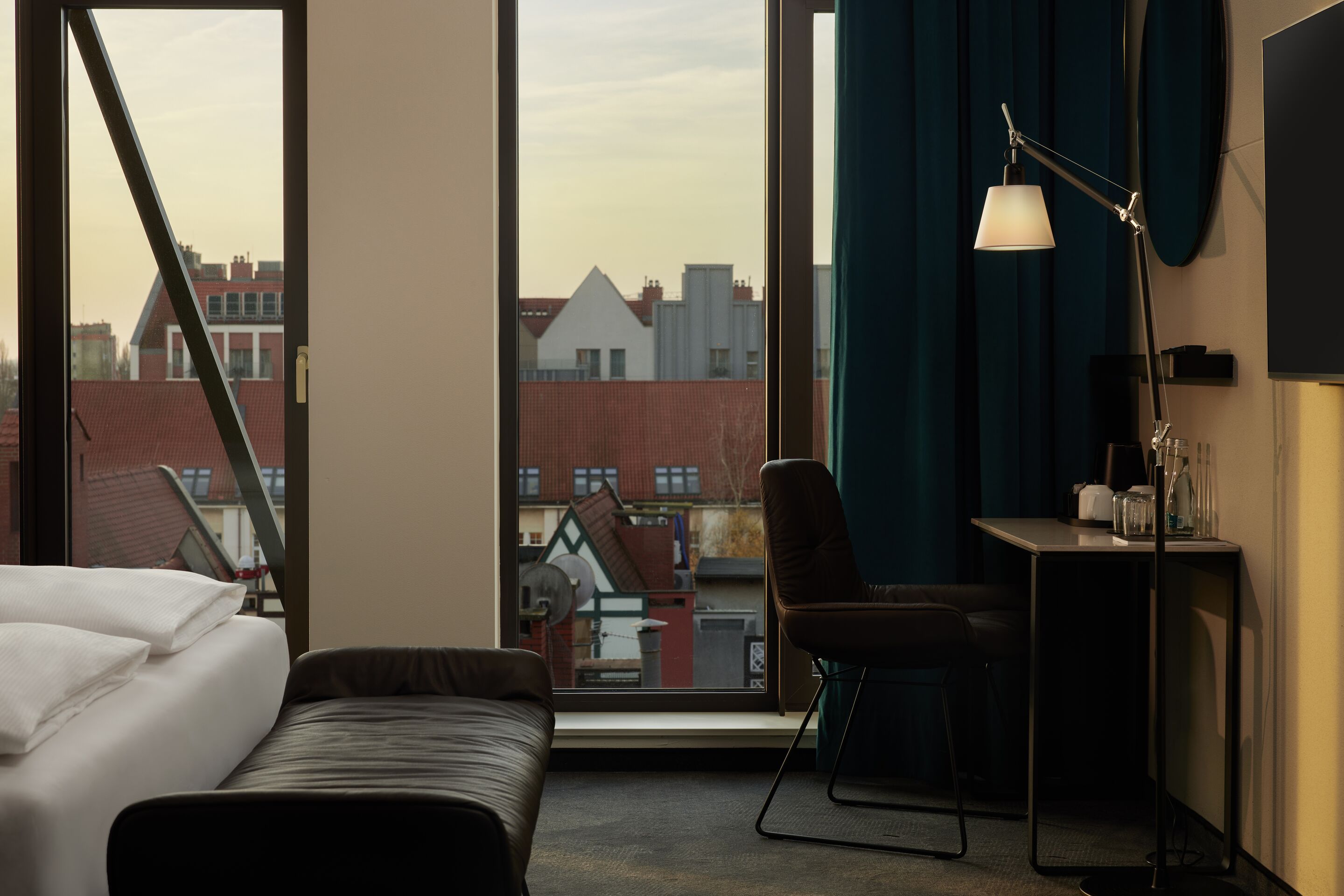 Hotel Danzig The Cloud One Zimmer mit Bettbank vor Bett, Tisch und Stuhl sowie zwei bodentiefe Fenster