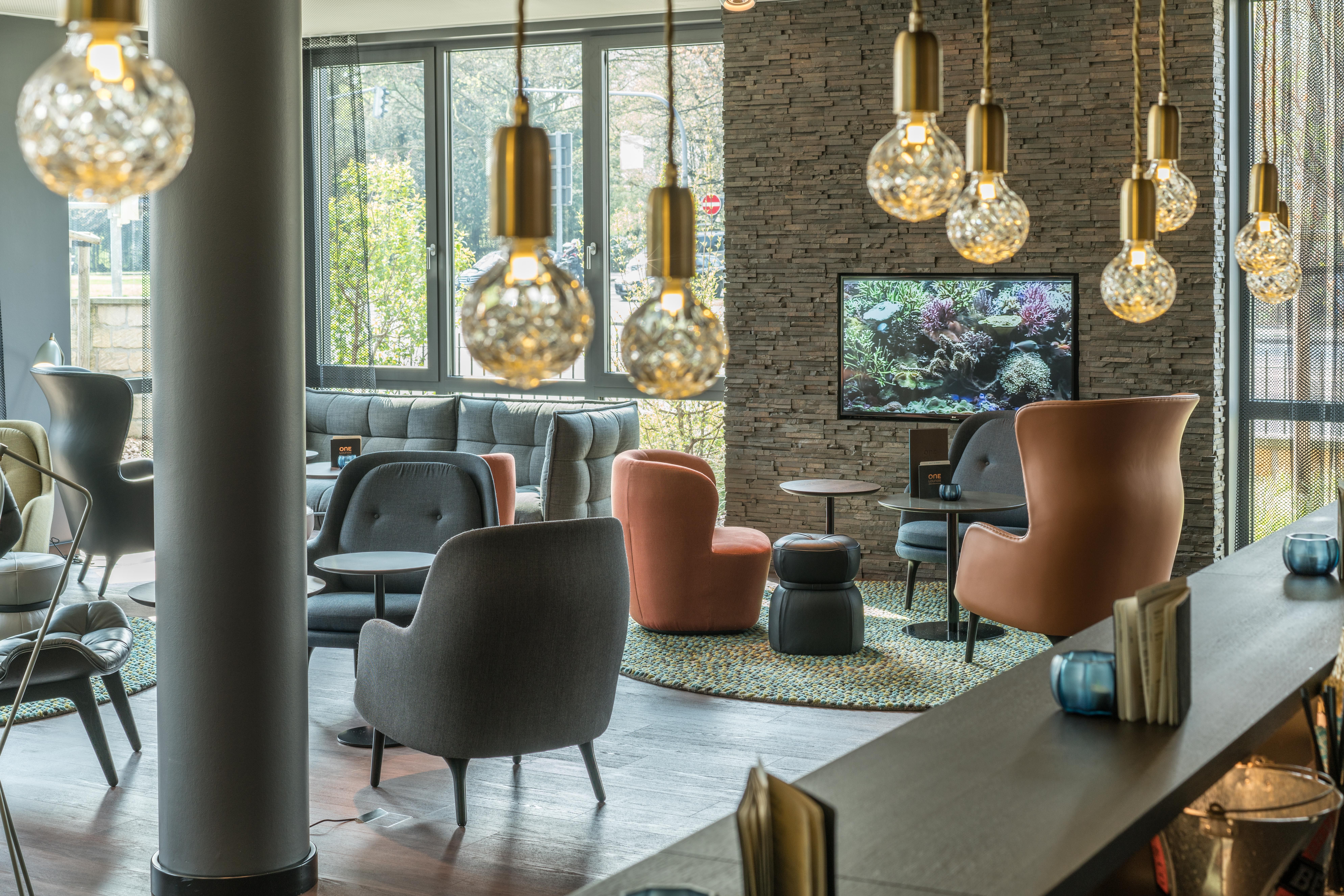 hotel Dresden Palaisplatz Motel One light-filled lounge with multiple seating areas and floor-to-ceiling windows