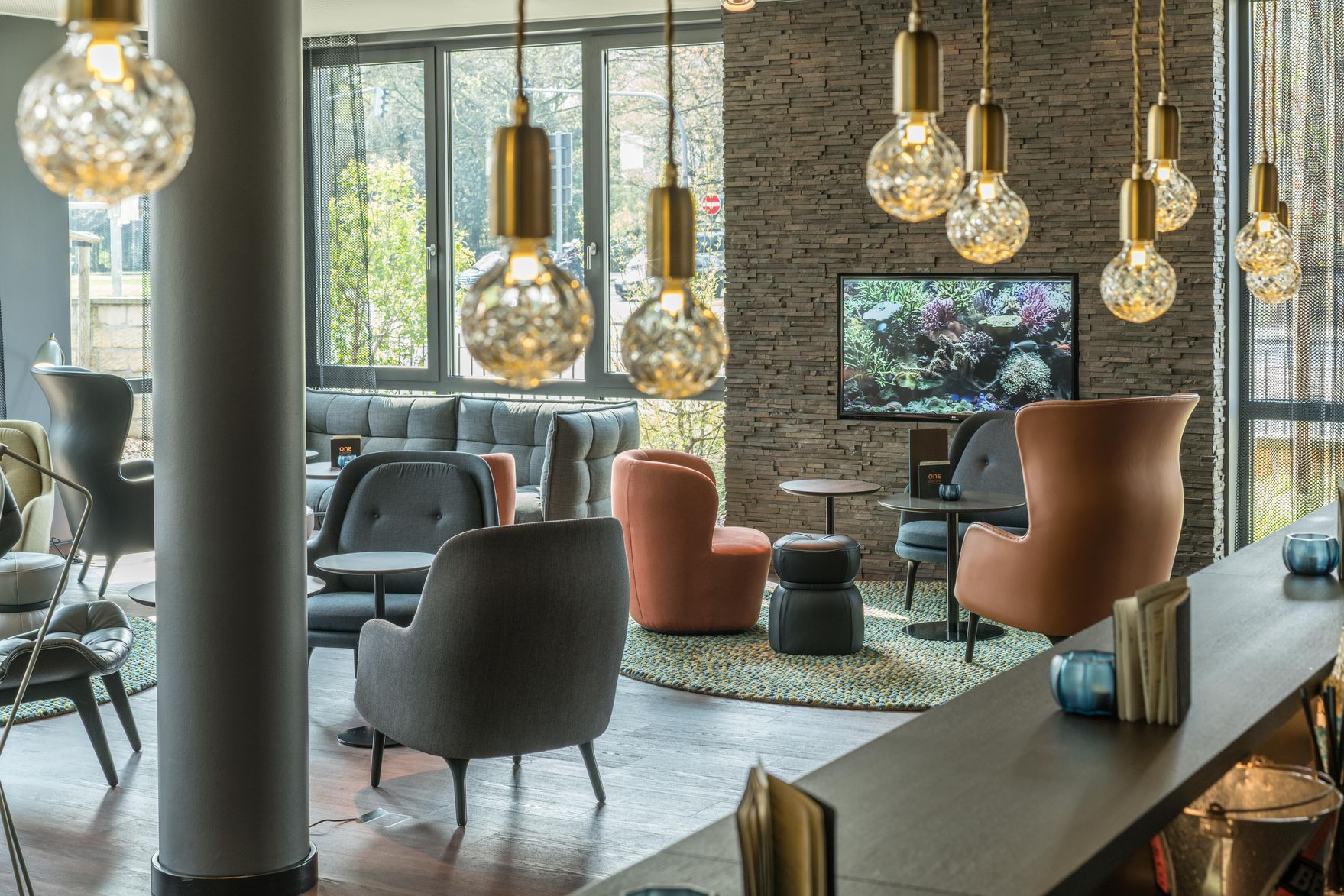 Hotel Dresden Palaisplatz Motel One lichtdurchflutete Lounge mit mehreren Sitzgelegenheiten und bodentiefen Fenstern