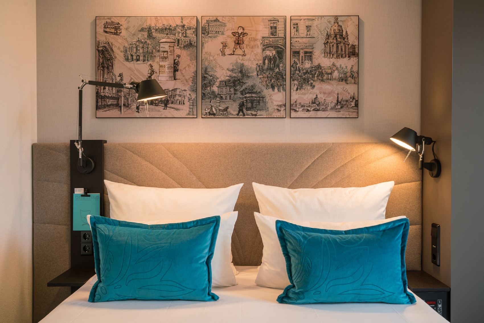 Designhotel Dresden Palaisplatz Motel One Blick auf ein komfortables Doppelbett mit zwei Zierkissen in türkis