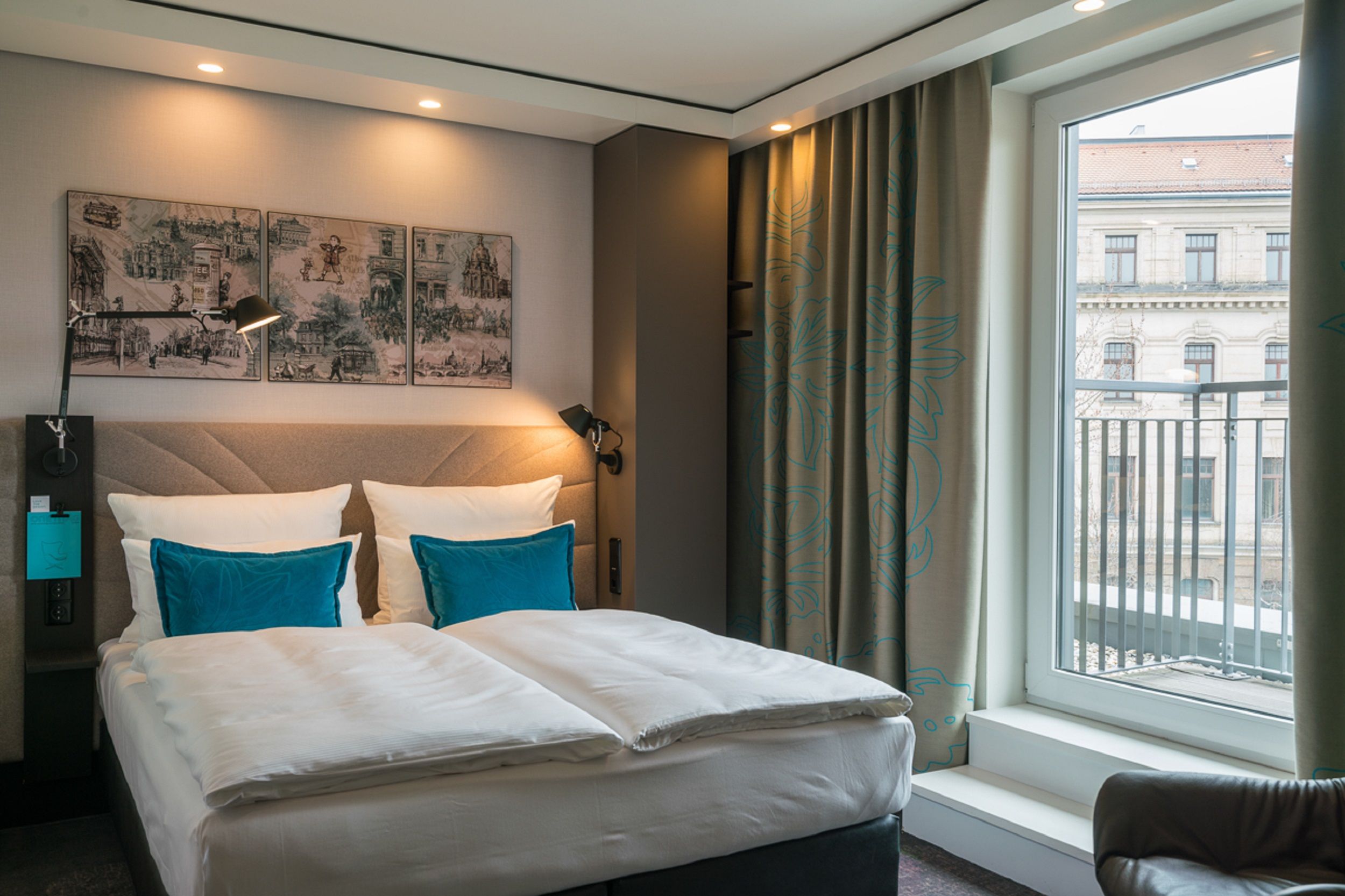 Hotel Dresden Palaisplatz Motel One Zimmer mit Blick auf komfortables Doppelbett und Balkonzugang