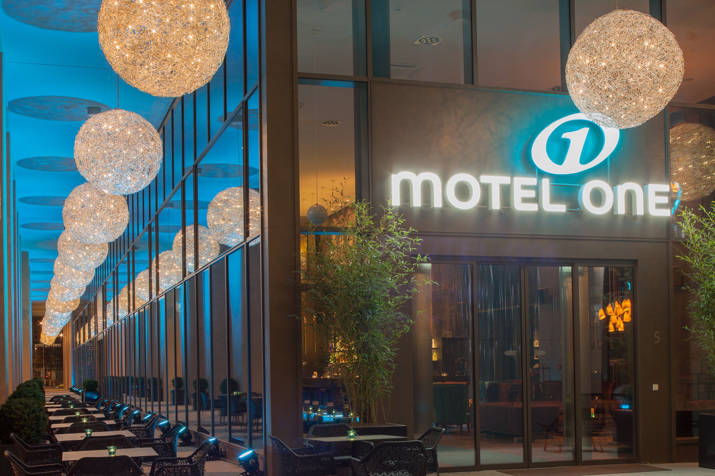 Hotel Dresden am Zwinger Motel One Blick auf den Außenbereich sowie die Eingangstür mit leuchtendem Logo