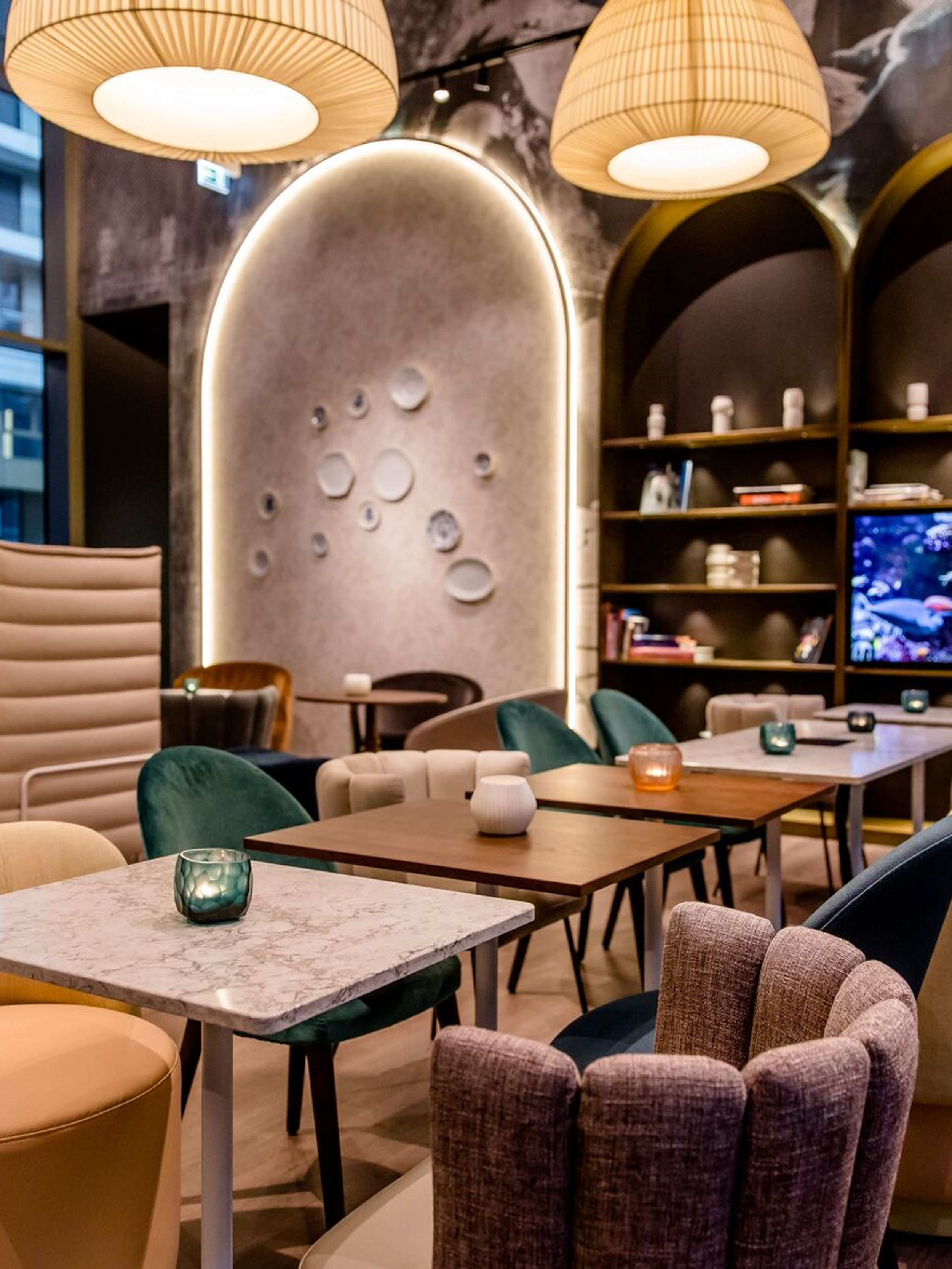 Designhotel Dresden am Zwinger Motel One Lounge mit mehreren Tischen und Stühlen
