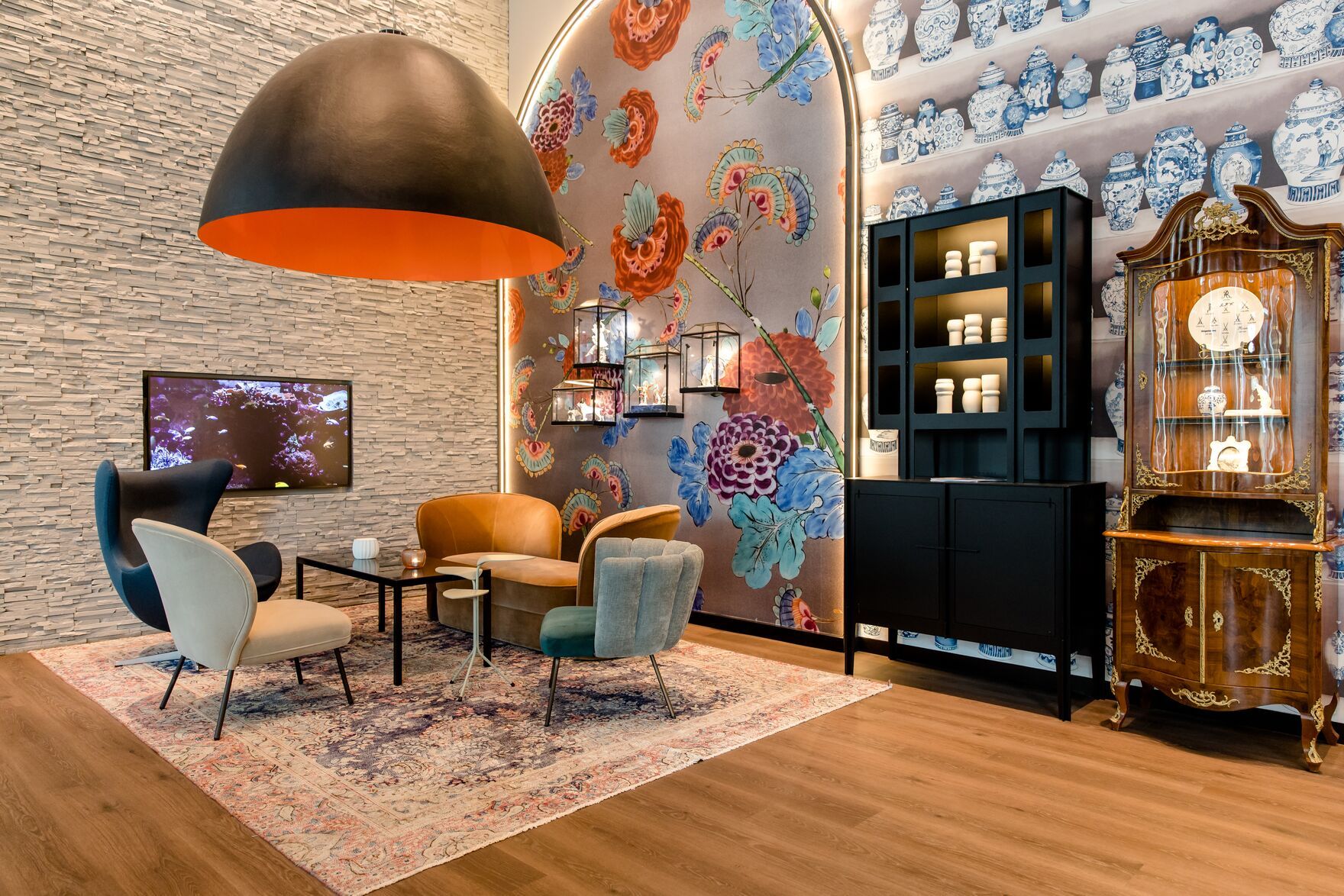 Designhotel Dresden am Zwinger Motel One Lounge mit Sesselgruppe und hohen Vitrinen