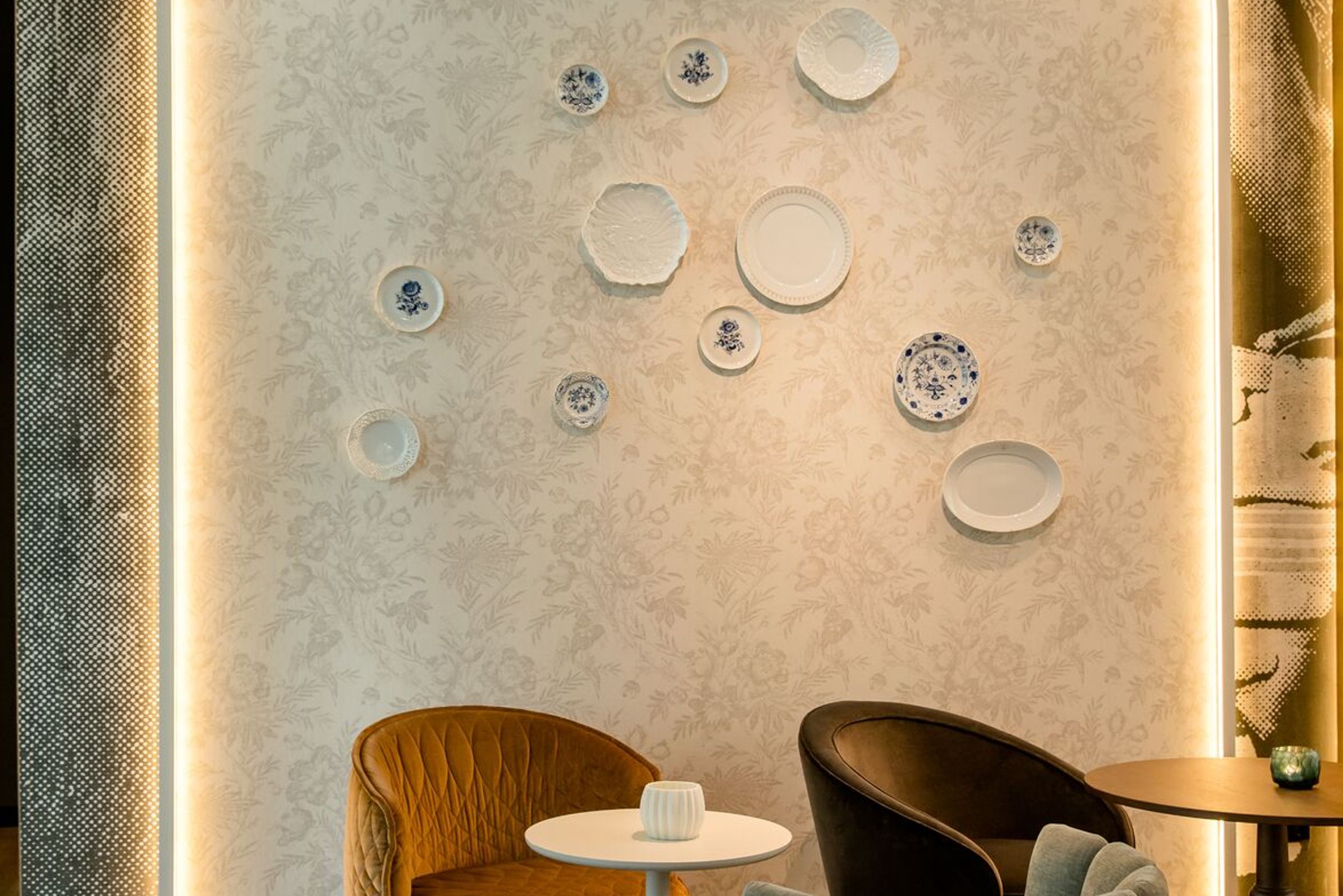 hotel Dresden am Zwinger Motel One lounge with armchairs and tables in front of a light-colored wall with indirect lighting