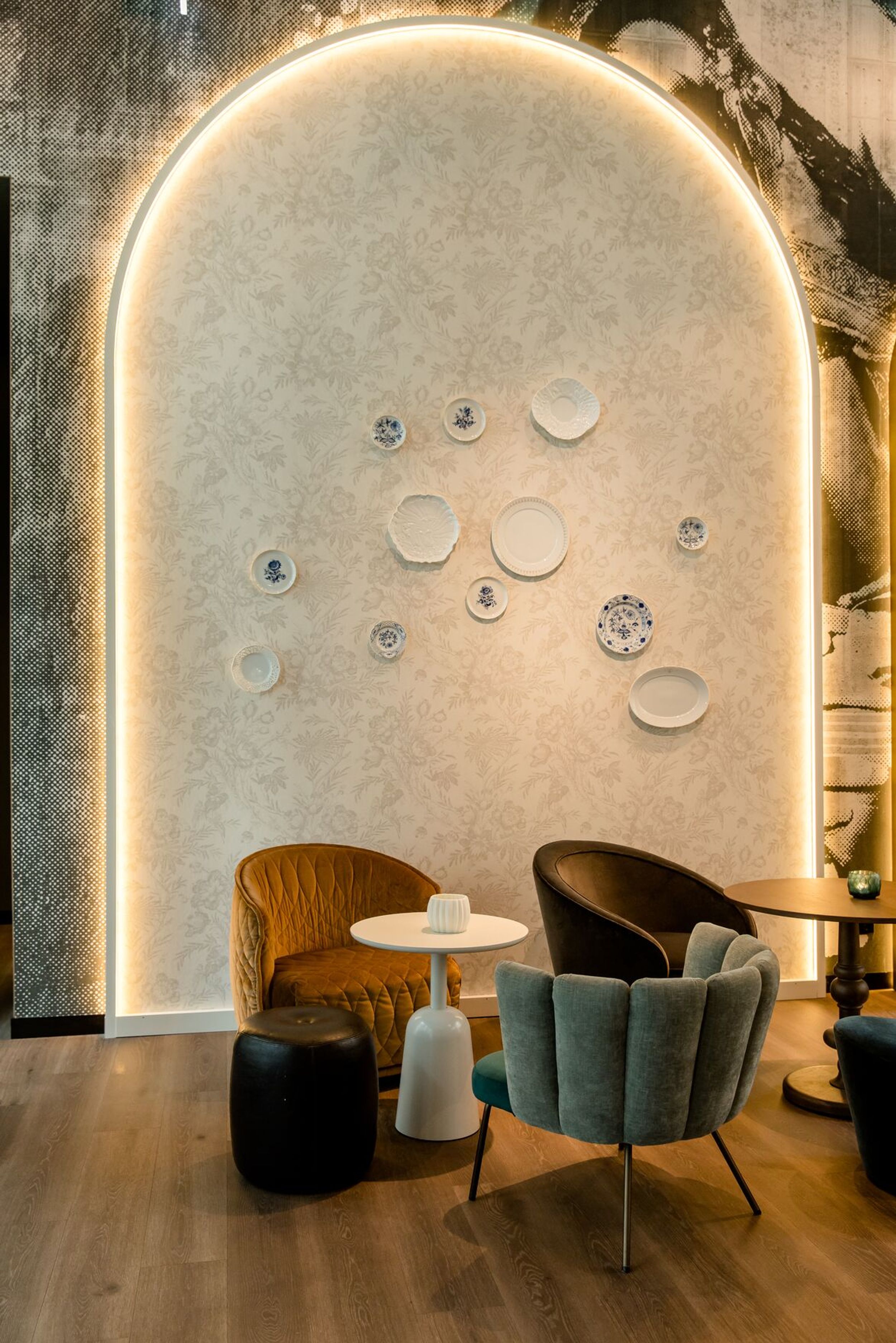 Hotel Dresden am Zwinger Motel One Lounge mit Sesseln und Tischen vor heller Wand mit indirekter Beleuchtung