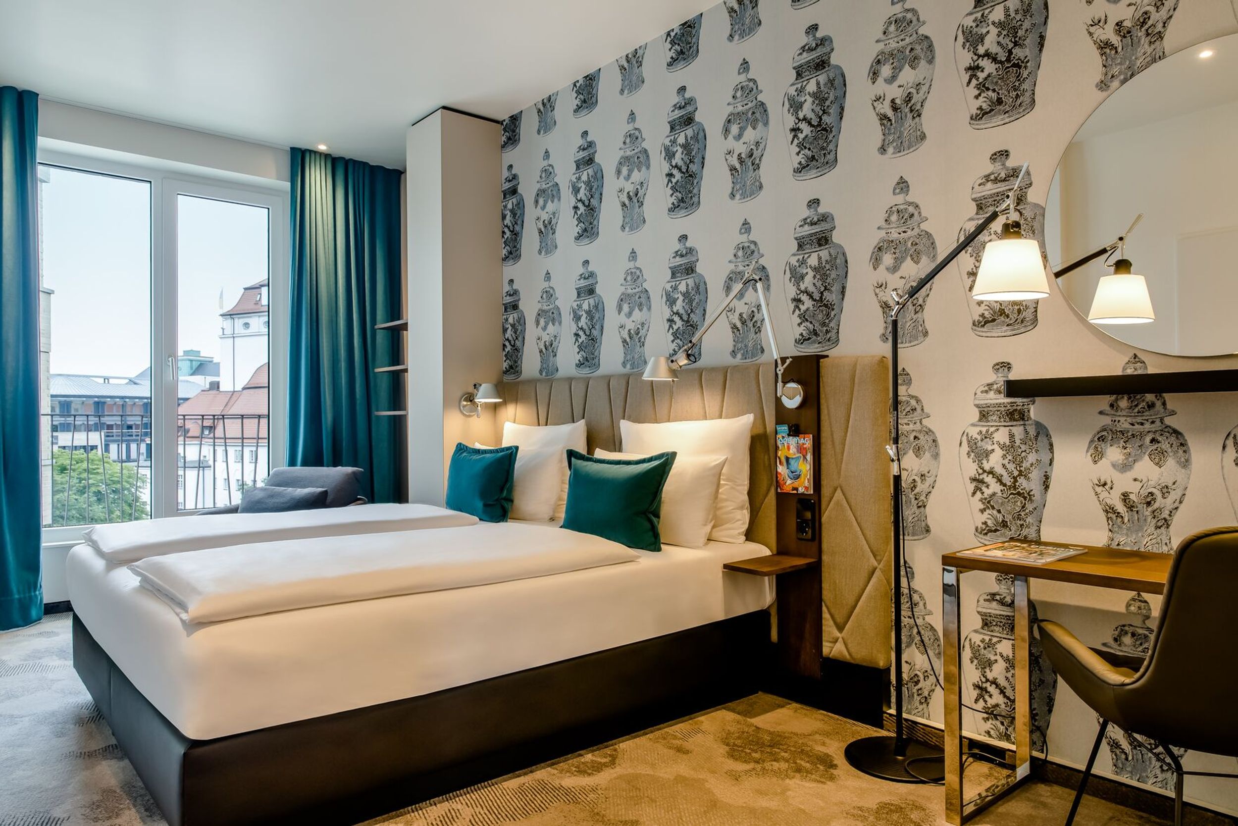 Hotel Dresden am Zwinger Motel One seitlicher Blick in lichtdurchflutetes Zimmer mit großem Doppelbett