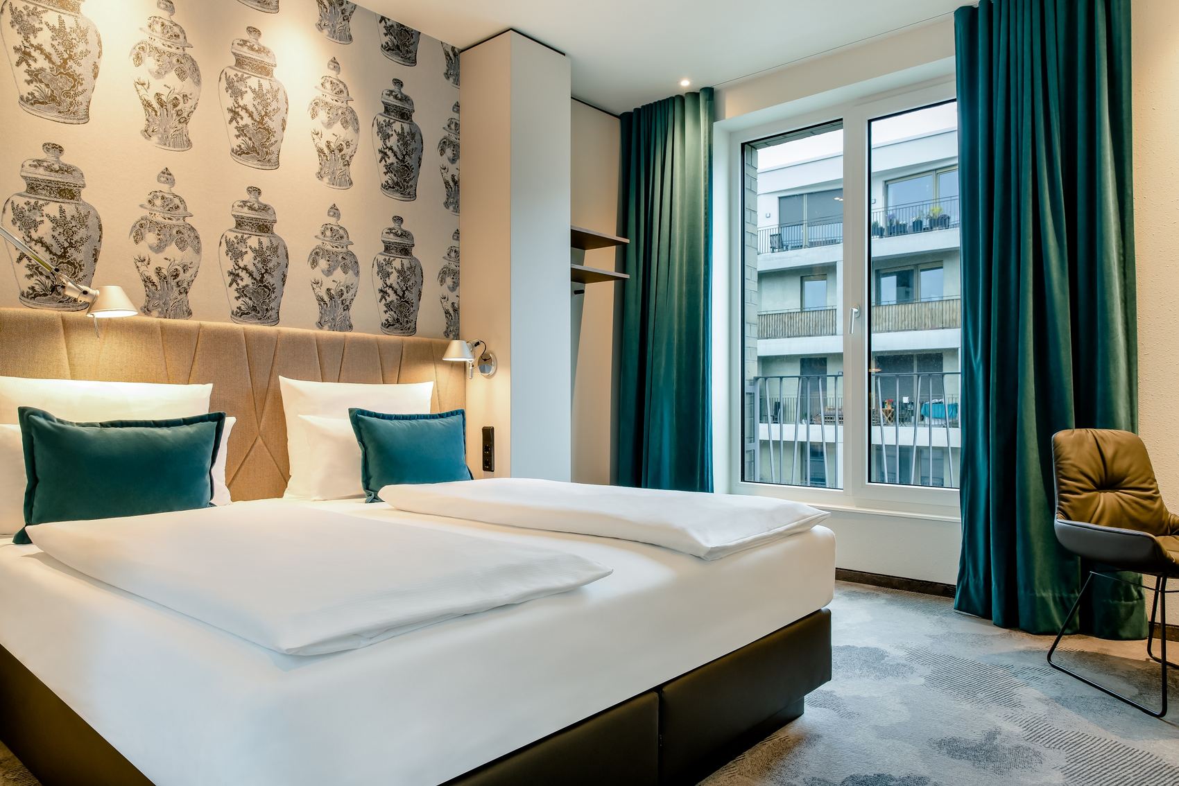 designhotel Dresden am Zwinger Motel One spacious room with double bed, armchair, open closet shelves, and floor-to-ceiling windows