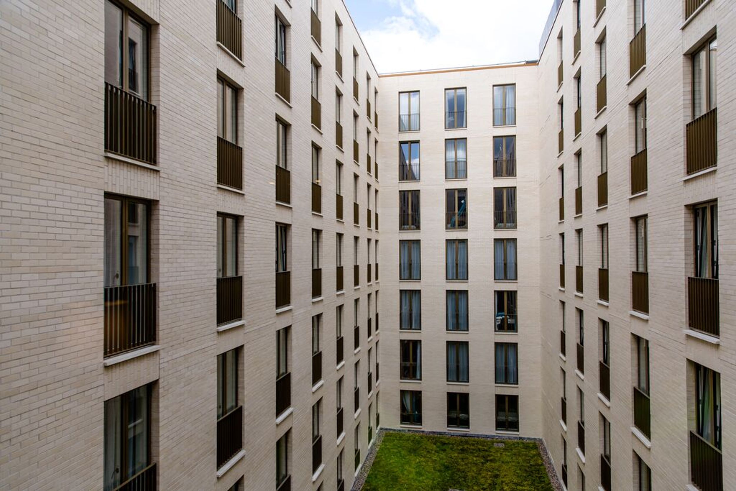 designhotel Dublin Motel One View of the facade with a view of the inner courtyard with green lawn