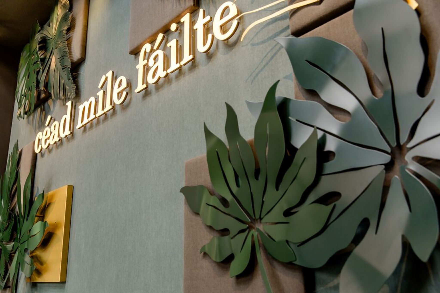 Hotel Dublin Motel One Wand mit Blättern als Dekoration sowie Schriftzug "céad mile fáilte"