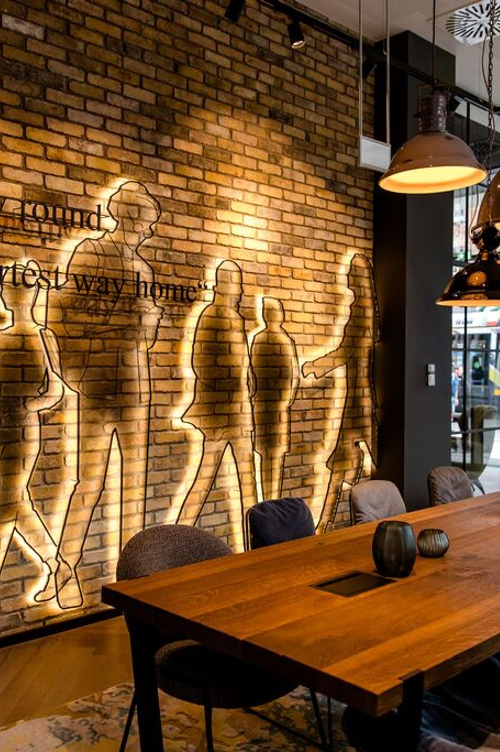 Hotel Dublin Motel One helle Lounge mit Tisch, Stühlen und bodentiefen Fenstern