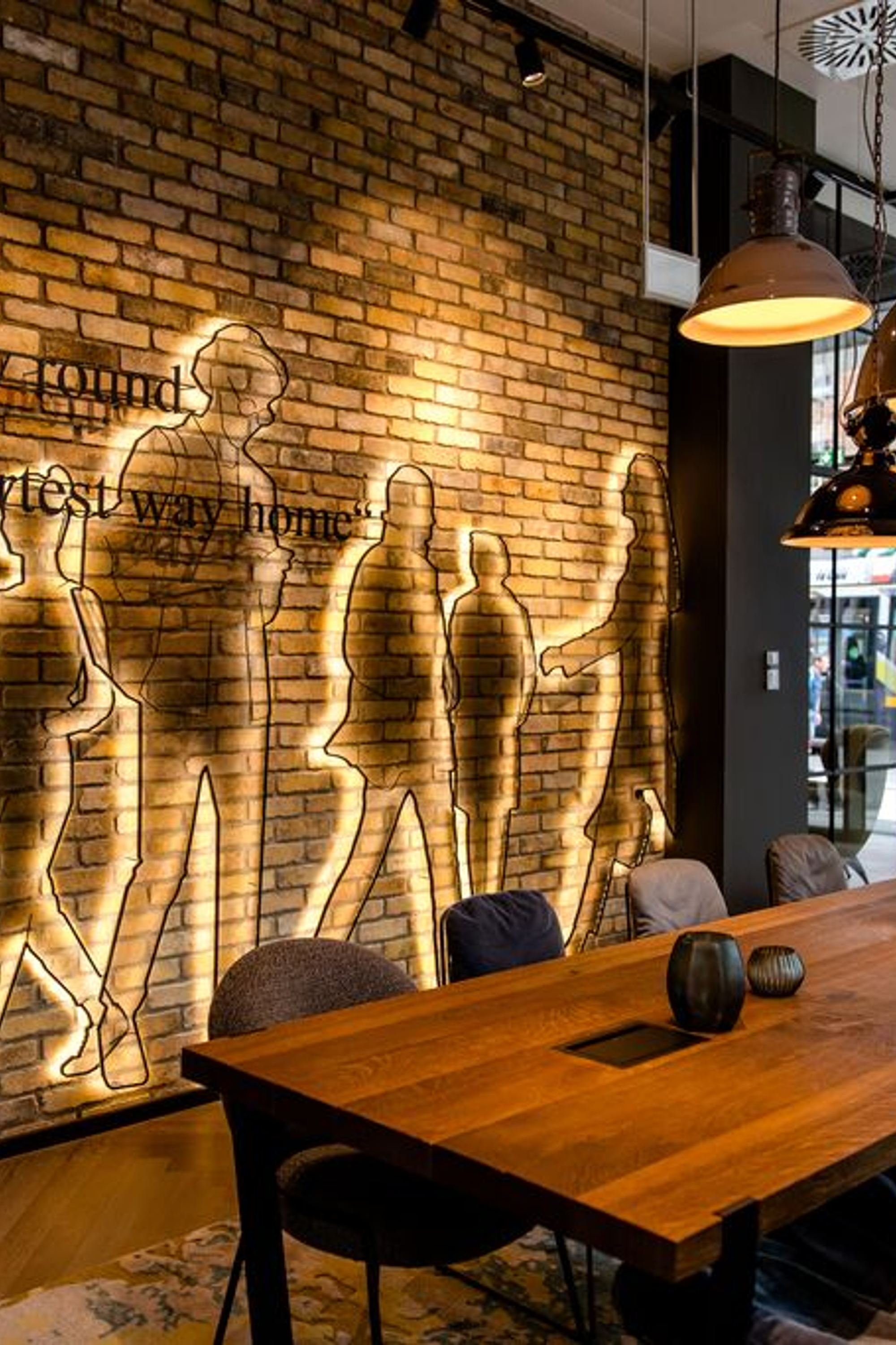 Hotel Dublin Motel One helle Lounge mit Tisch, Stühlen und bodentiefen Fenstern