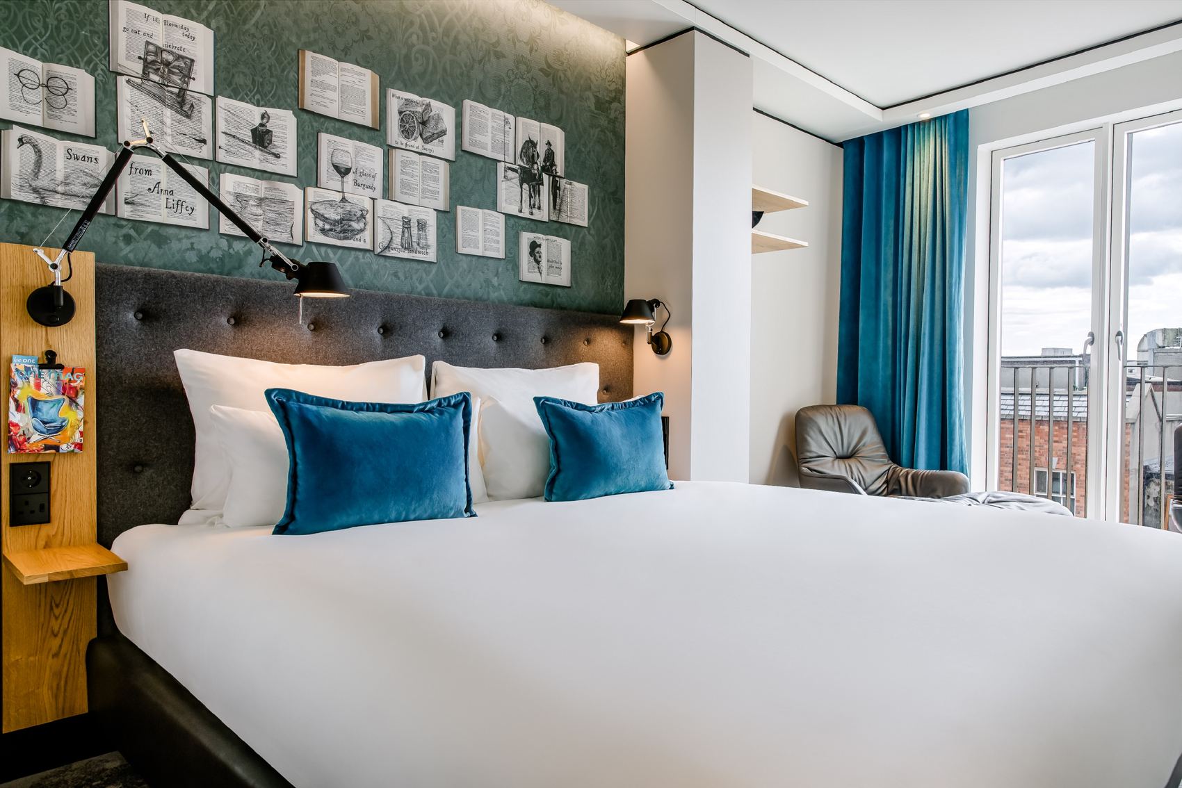 Designhotel Dublin Motel One seitlicher Blick auf großes Doppelbett und bodentiefes Fenster