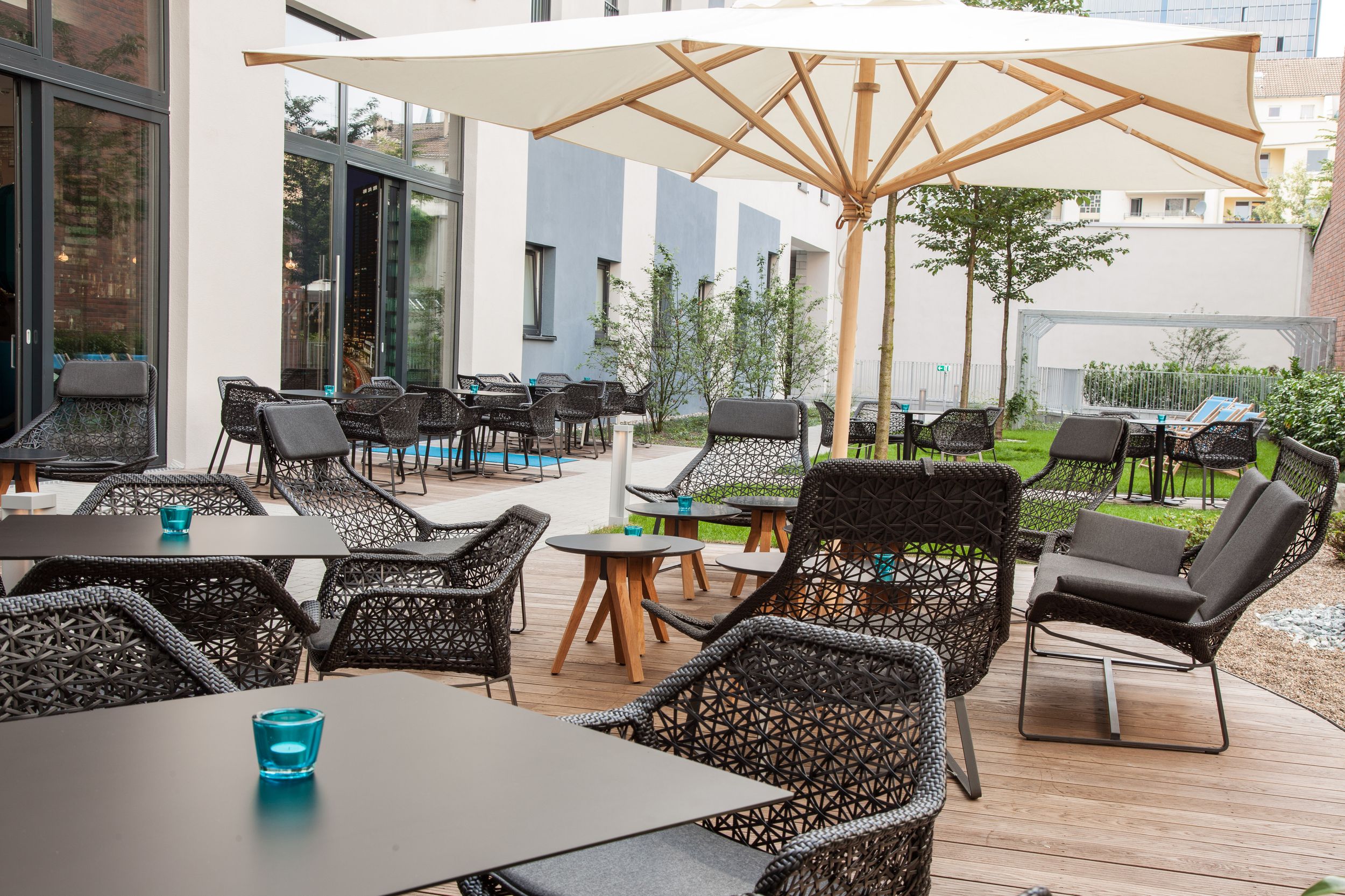 Hotel Düsseldorf Hauptbahnhof Motel One Terrasse mit mehreren Sitzgelegenheiten und Sonnenschirmen