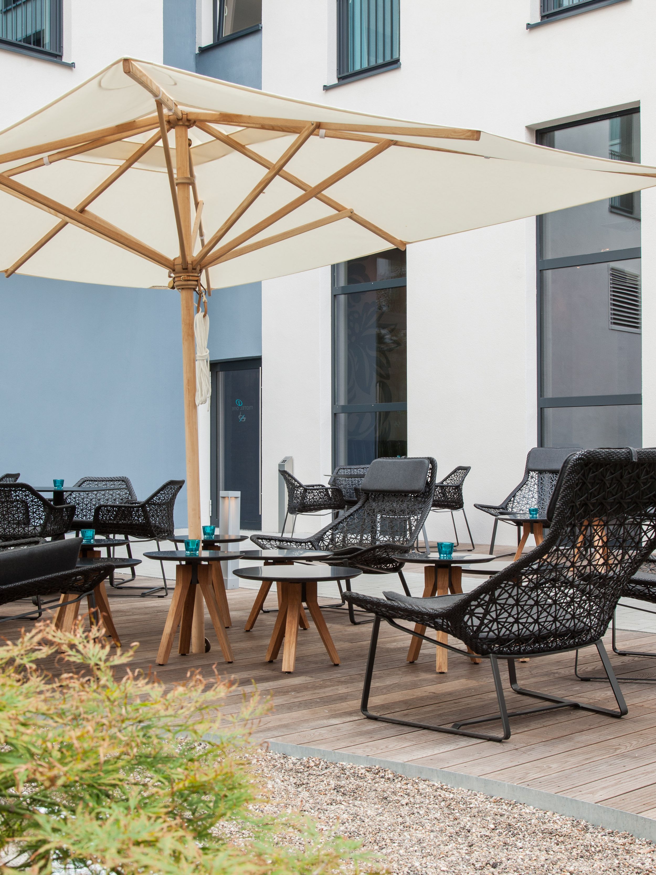hotel Düsseldorf Hauptbahnhof Motel One outdoor area with seating and light-colored parasol