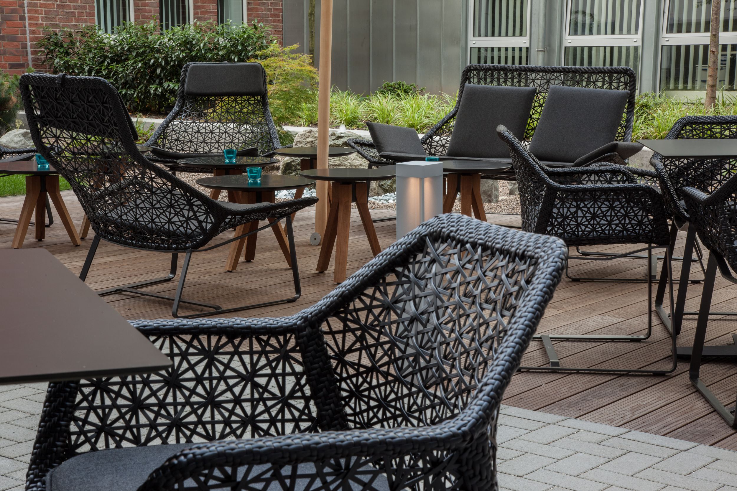 Designhotel Düsseldorf Hauptbahnhof Motel One Terrasse mit Blick auf mehrere Stühle und Beistelltische