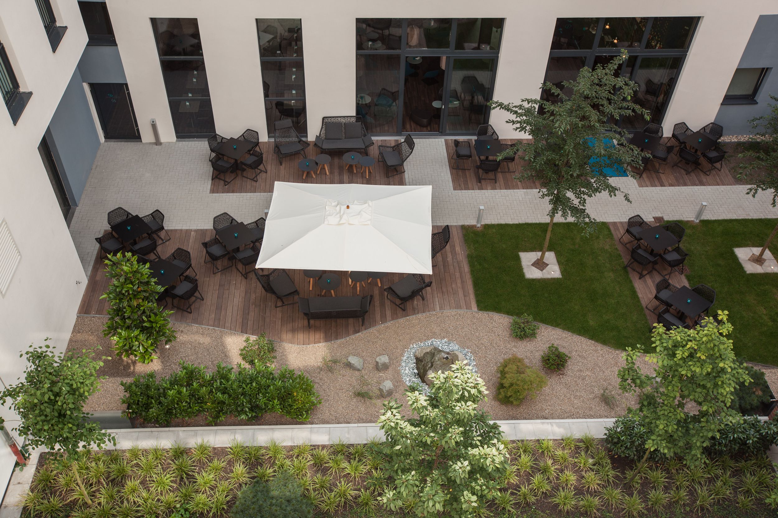 Hotel Düsseldorf Hauptbahnhof Motel One Blick von oben auf die Terrasse mit mehreren Sitzgelegenheiten