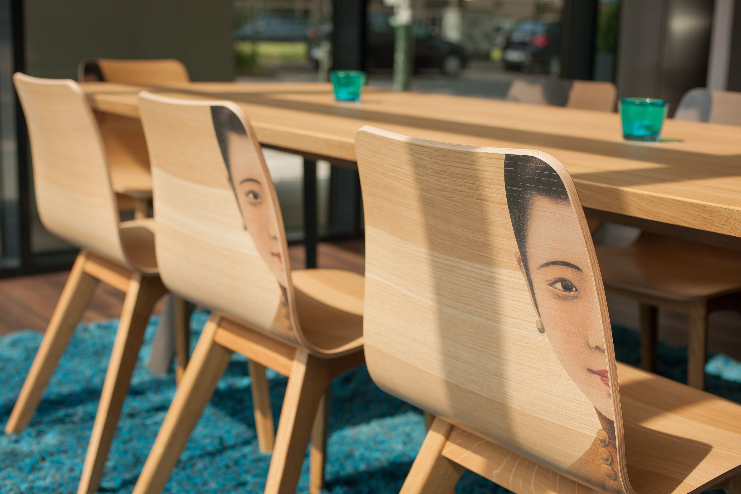 Hotel Düsseldorf Hauptbahnhof Motel One Tisch mit Stühlen, auf denen das halbe Gesicht einer Frau zu sehen ist