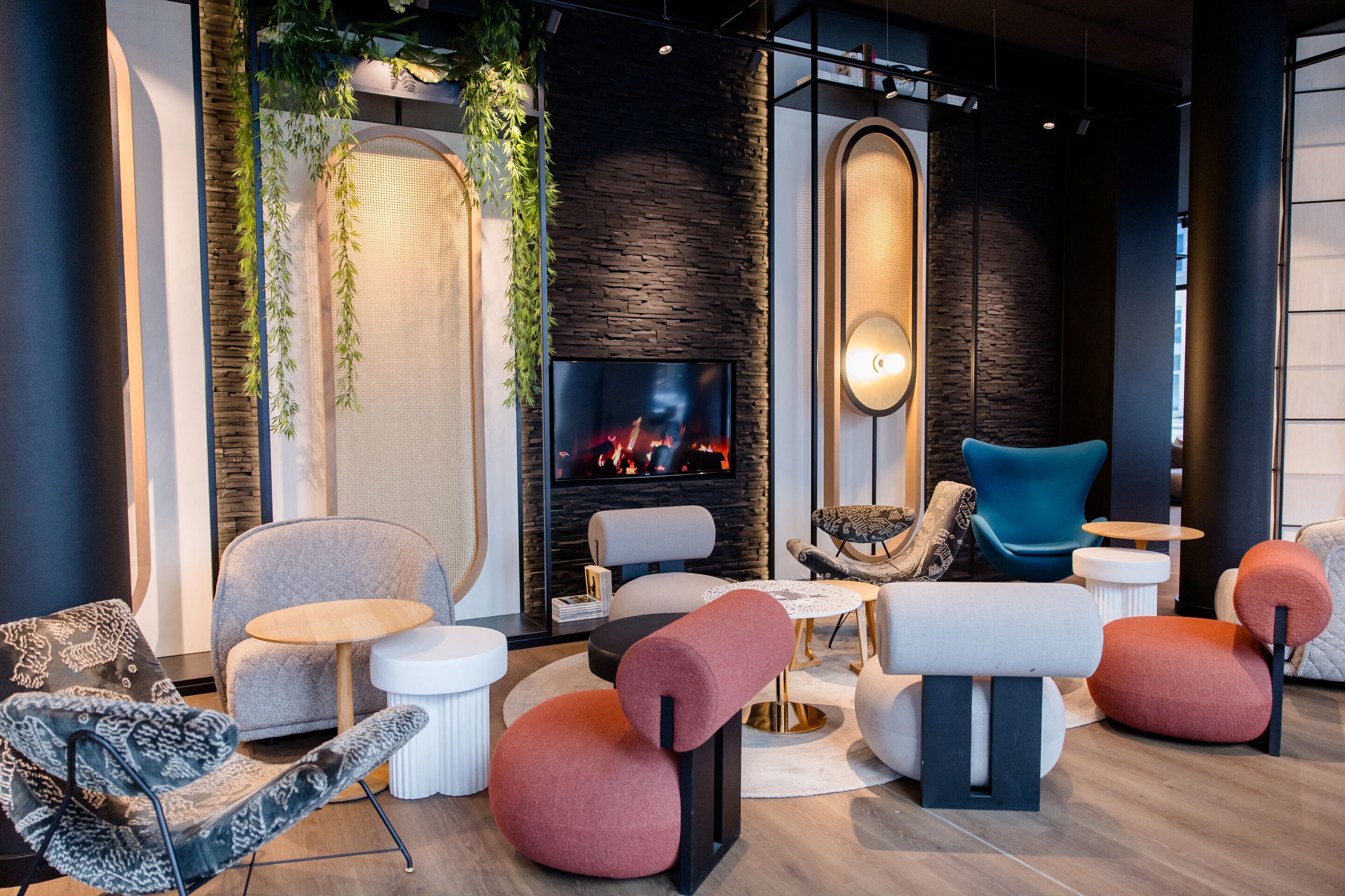 Design Hotel Düsseldorf Hauptbahnhof Motel One Lounge mit mehreren Sitzgelegenheiten und TV an der Wand