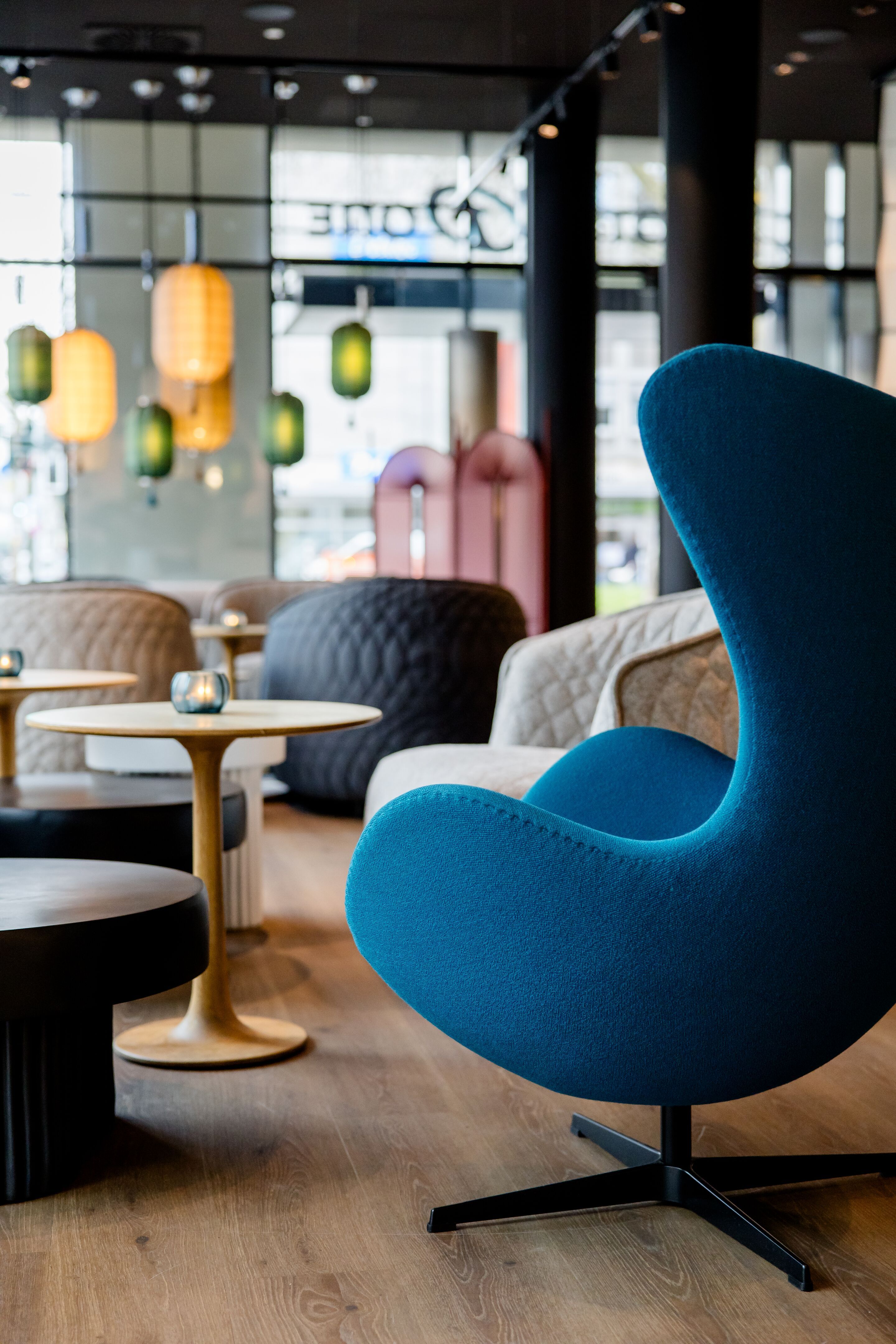 Hotel Düsseldorf Hauptbahnhof Motel One lichtdurchflutete Lounge mit Egg Chair im Vordergrund