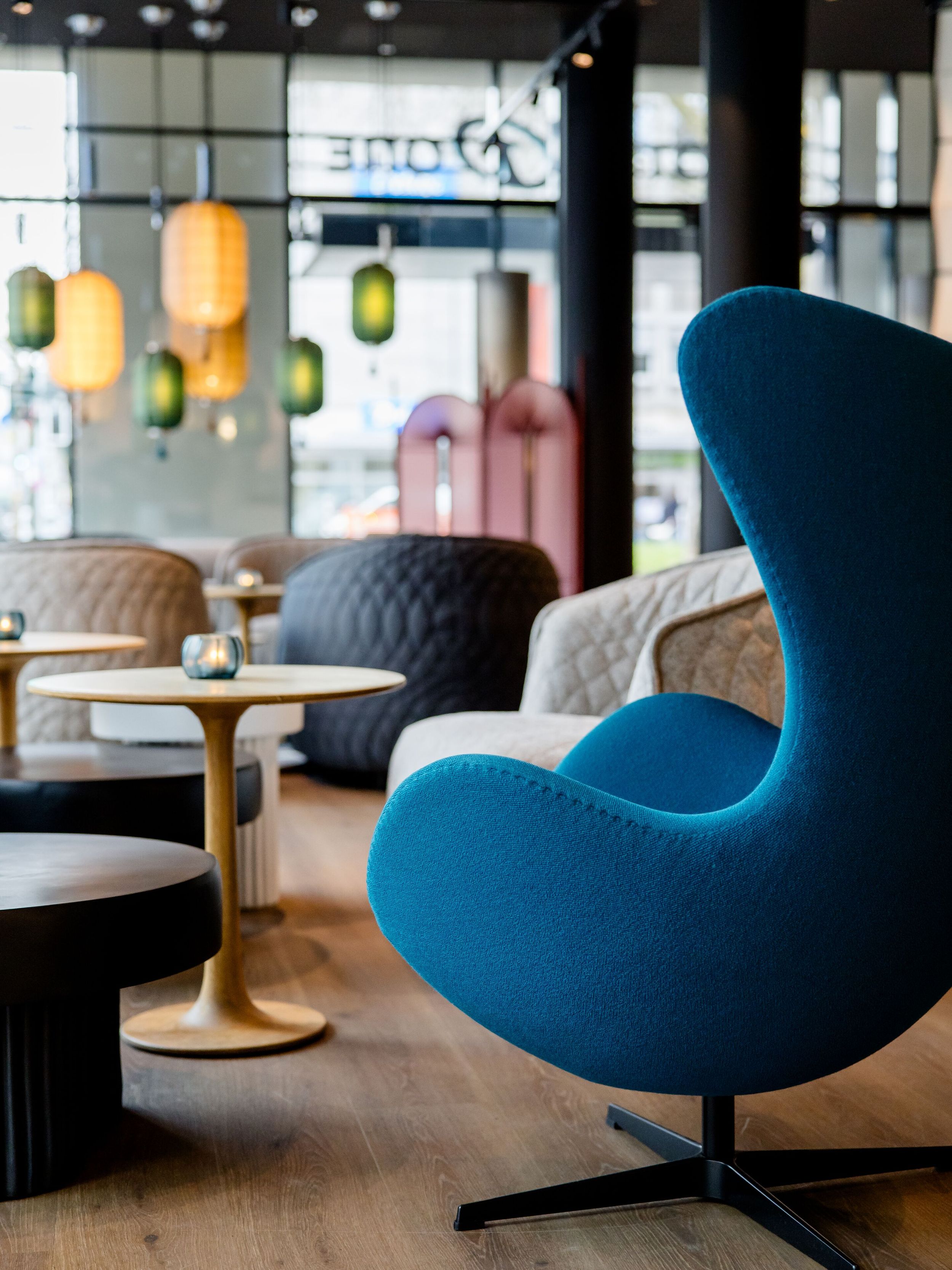 Hotel Düsseldorf Hauptbahnhof Motel One lichtdurchflutete Lounge mit Egg Chair im Vordergrund