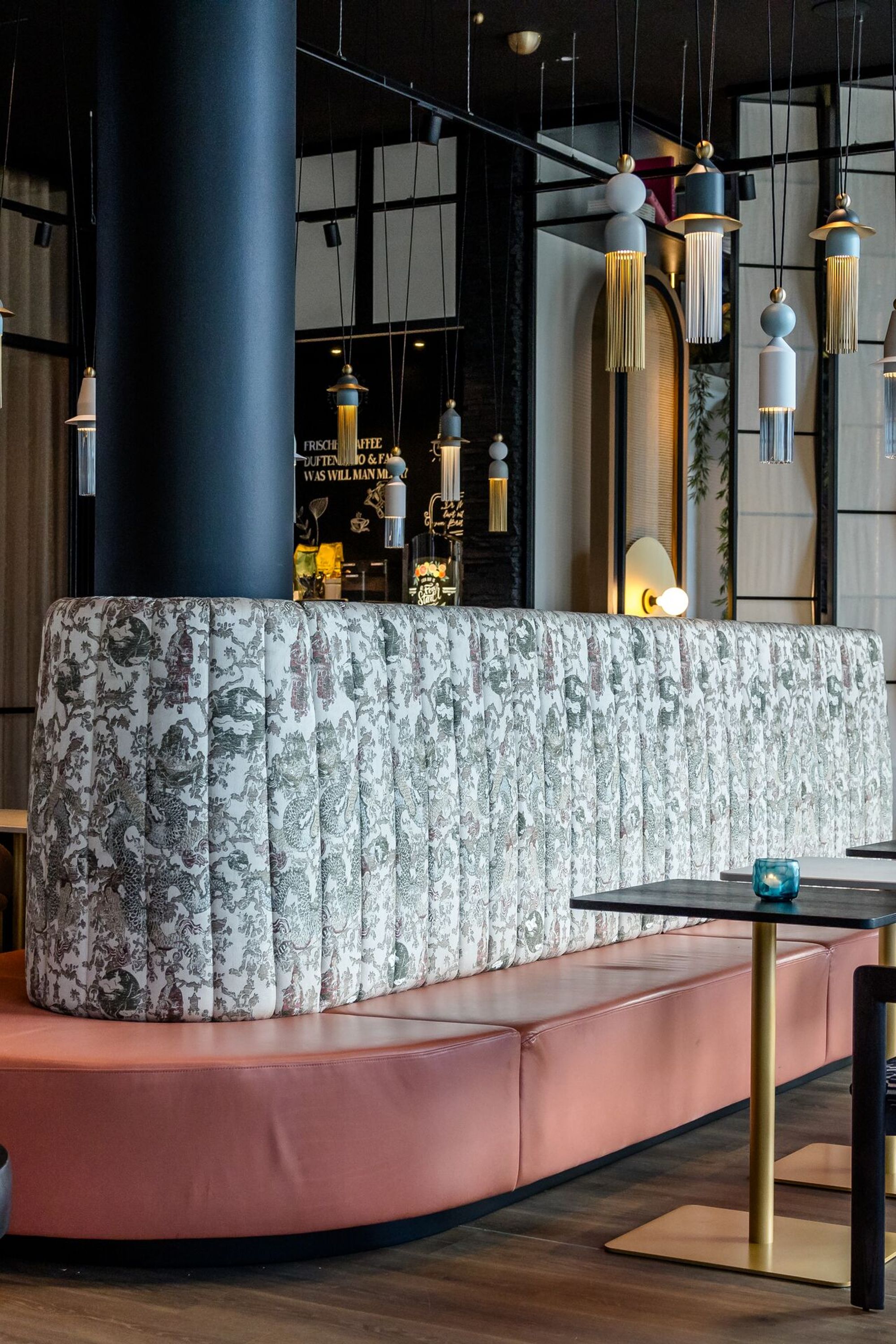 Designhotel Düsseldorf Hauptbahnhof Motel One lichtdurchflutete Lounge mit mehreren Tischen und Stühlen